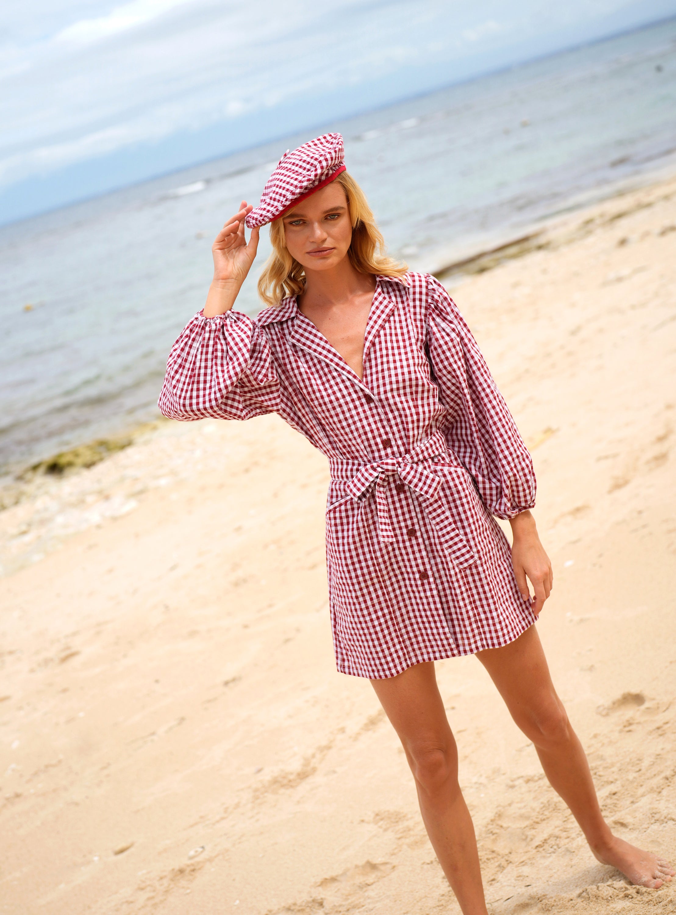 A stylish red gingham beret hat made from soft cotton with a comfortable linen lining, showcasing its eco-friendly design.