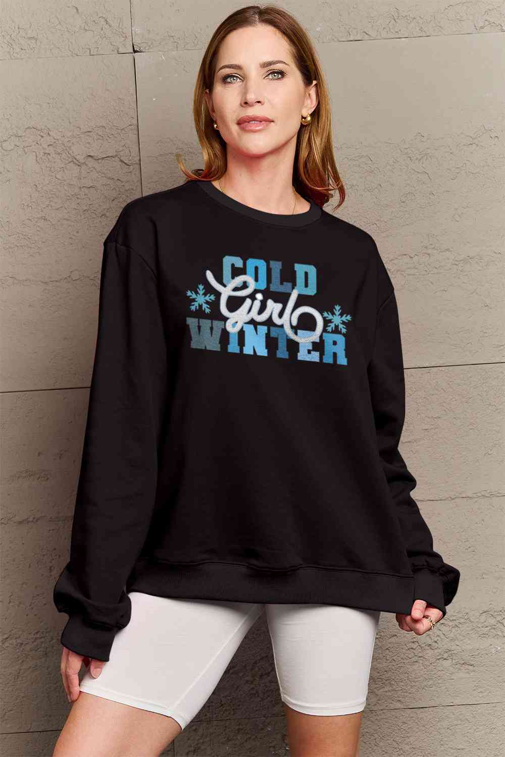 Simply Love Full Size COLD WINTER Graphic Long Sleeve Sweatshirt in a cozy setting, showcasing its stylish design and comfortable fit.