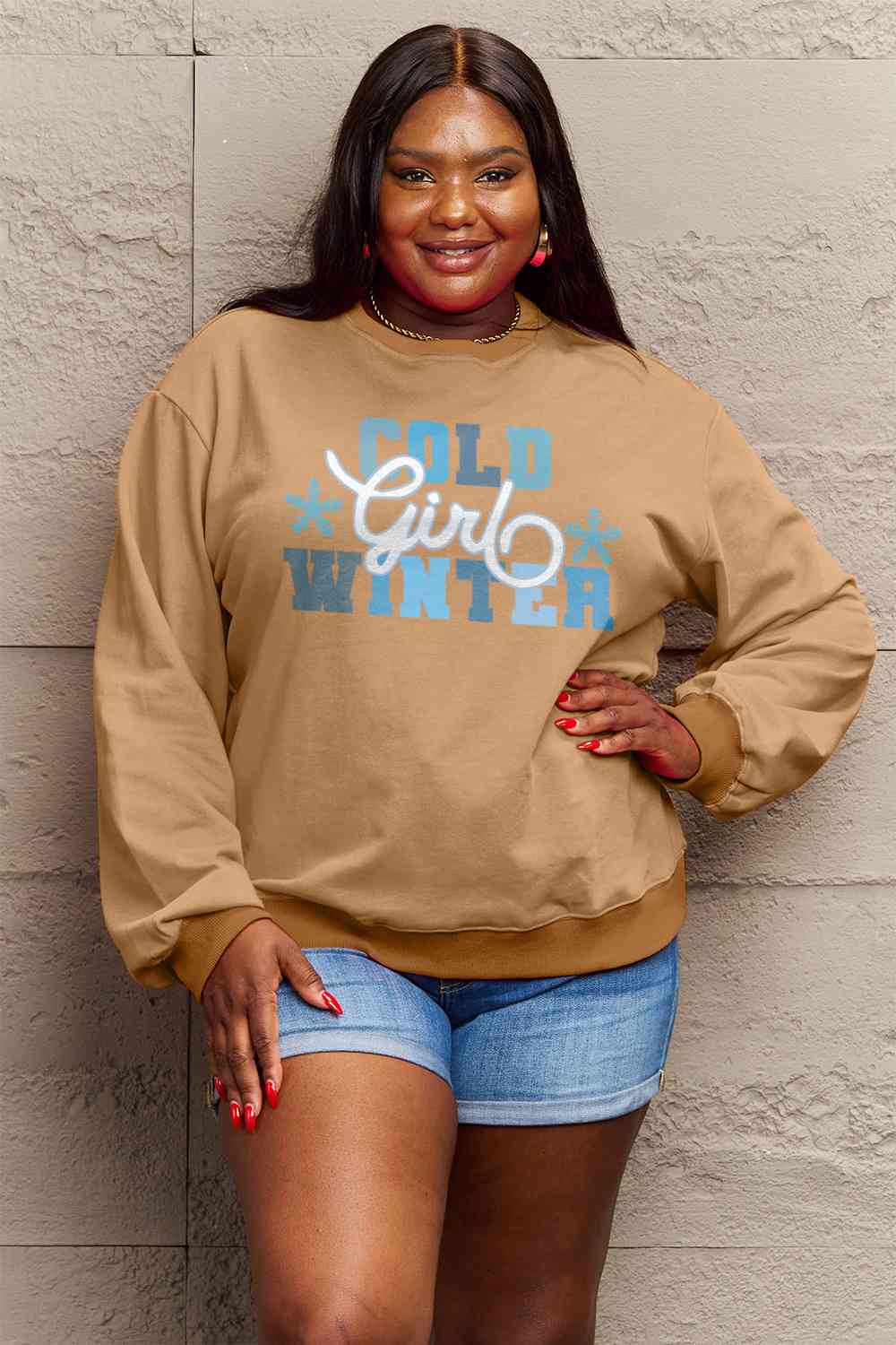 Simply Love Full Size COLD WINTER Graphic Long Sleeve Sweatshirt in a cozy setting, showcasing its stylish design and comfortable fit.