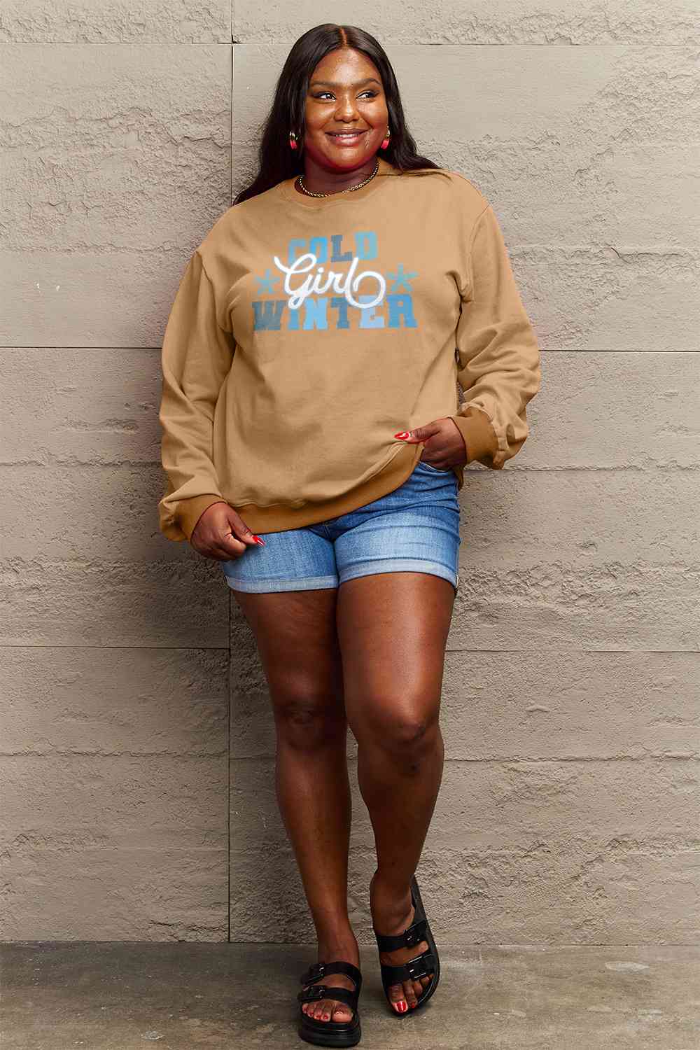 Simply Love Full Size COLD WINTER Graphic Long Sleeve Sweatshirt in a cozy setting, showcasing its stylish design and comfortable fit.