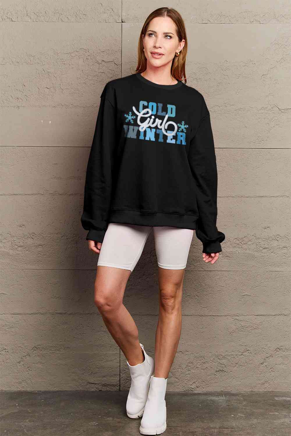 Simply Love Full Size COLD WINTER Graphic Long Sleeve Sweatshirt in a cozy setting, showcasing its stylish design and comfortable fit.