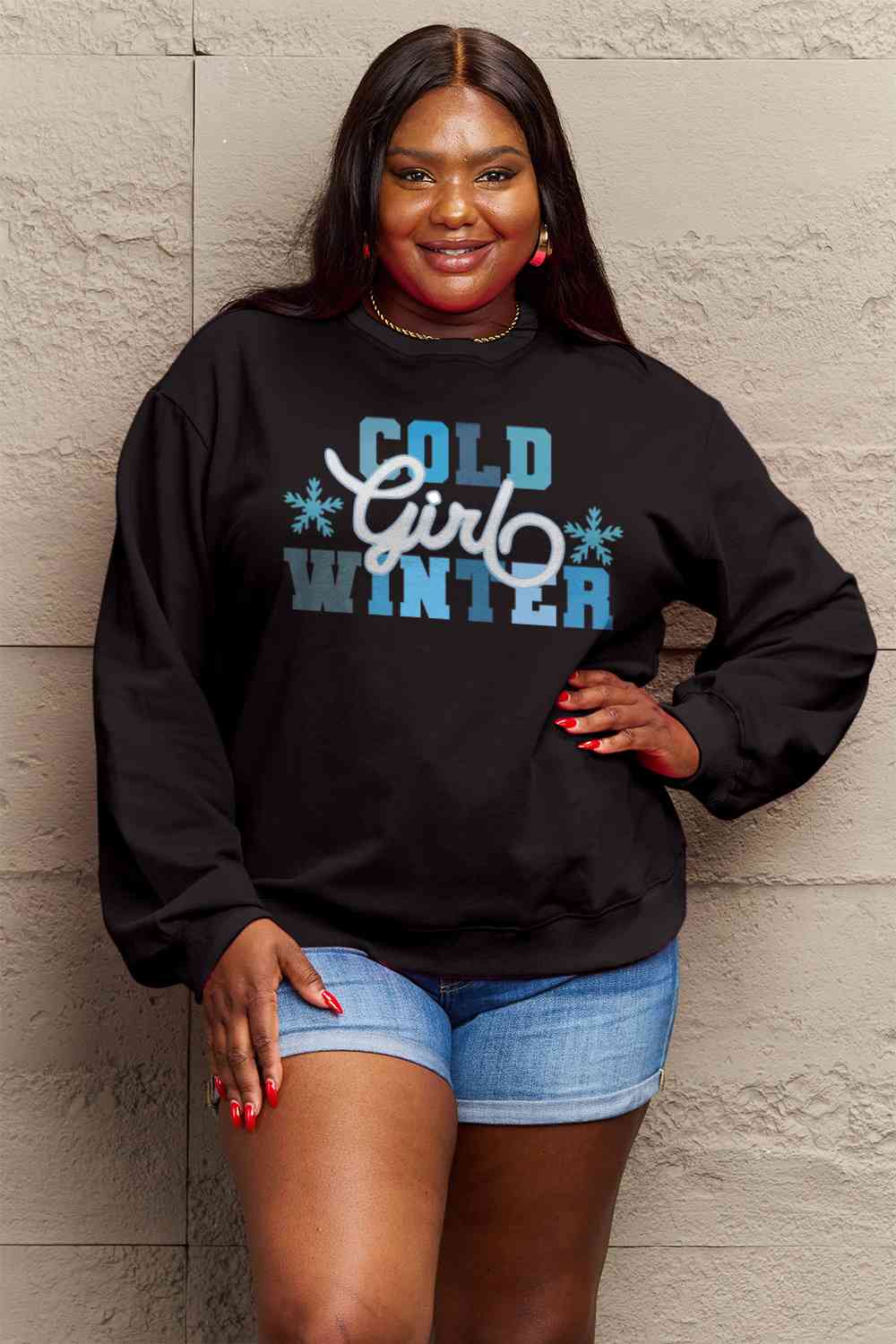 Simply Love Full Size COLD WINTER Graphic Long Sleeve Sweatshirt in a cozy setting, showcasing its stylish design and comfortable fit.