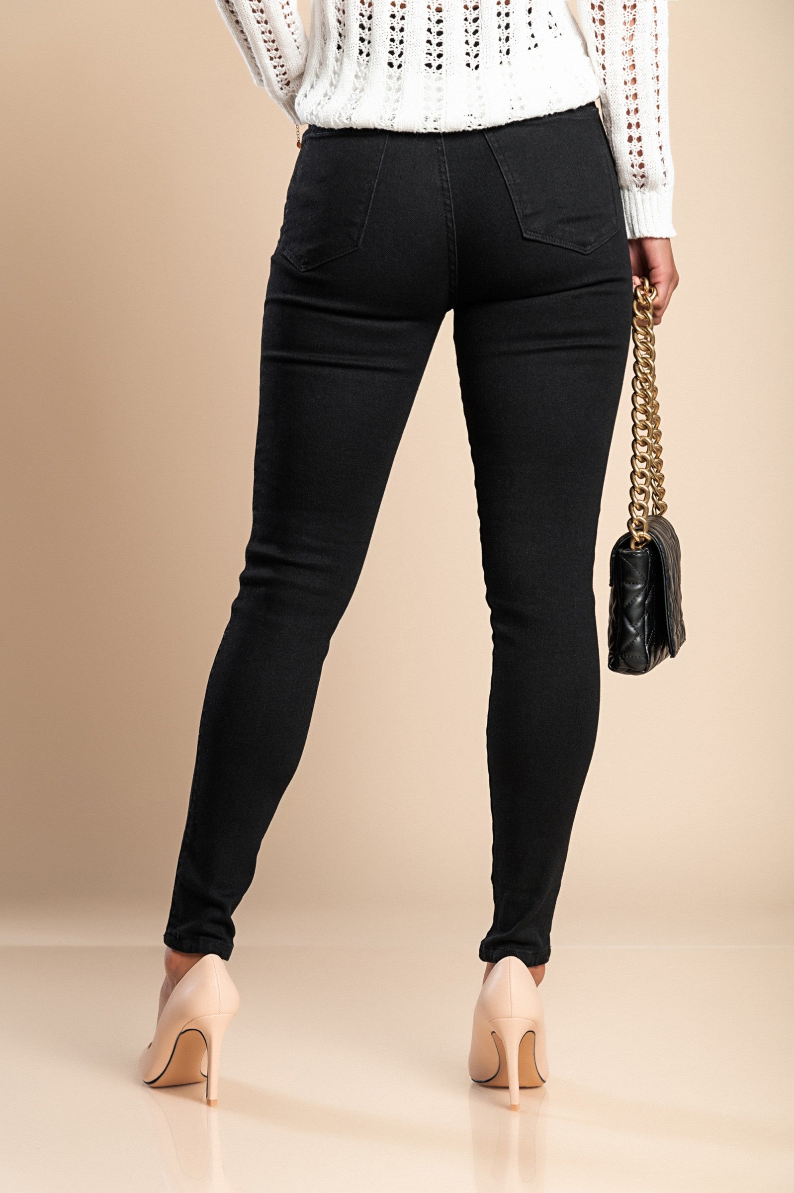 A pair of black skinny stretch jeans featuring a tapered leg, front and back pockets, zip and button closure, made from high-quality cotton.