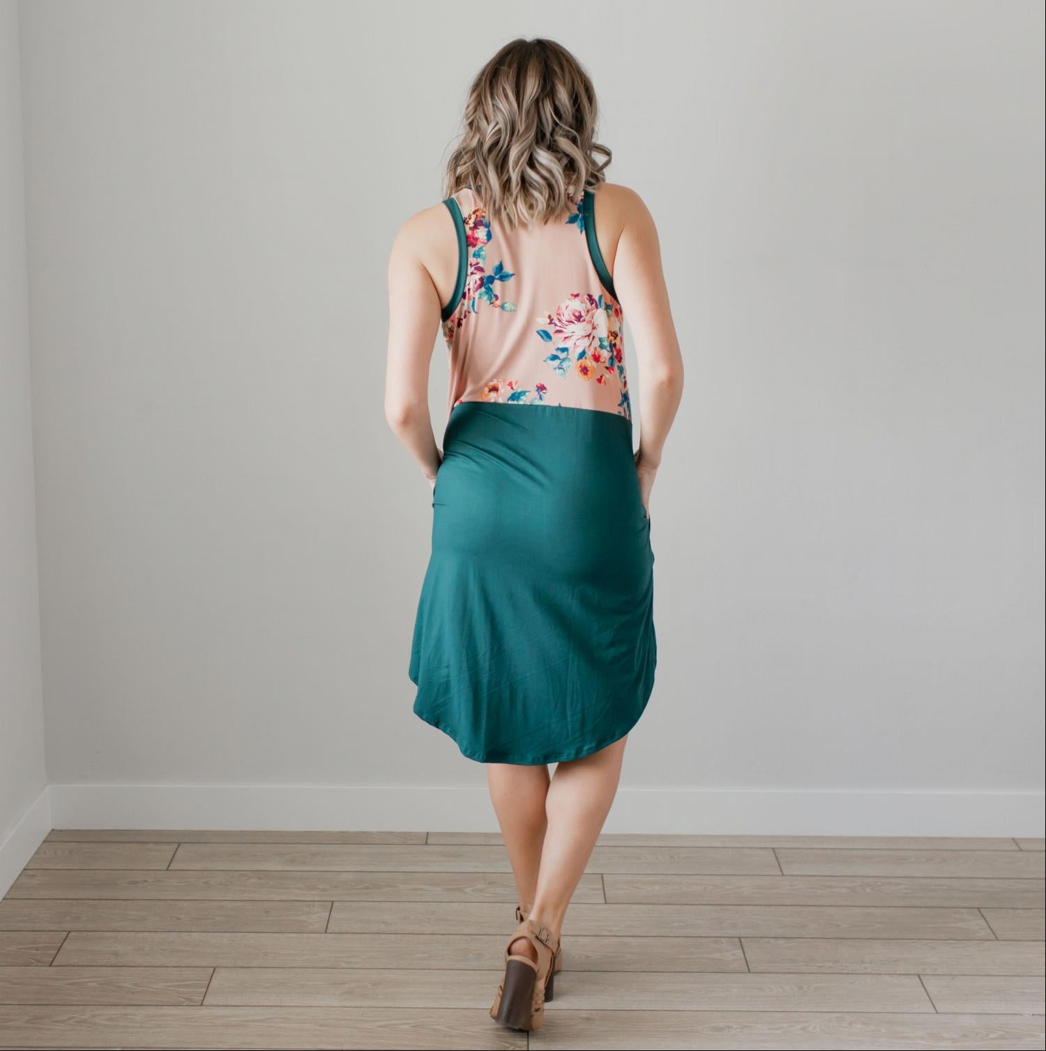 A stylish sleeveless floral dress featuring a pattern-blocked design with a floral top and solid bottom, perfect for summer wear.