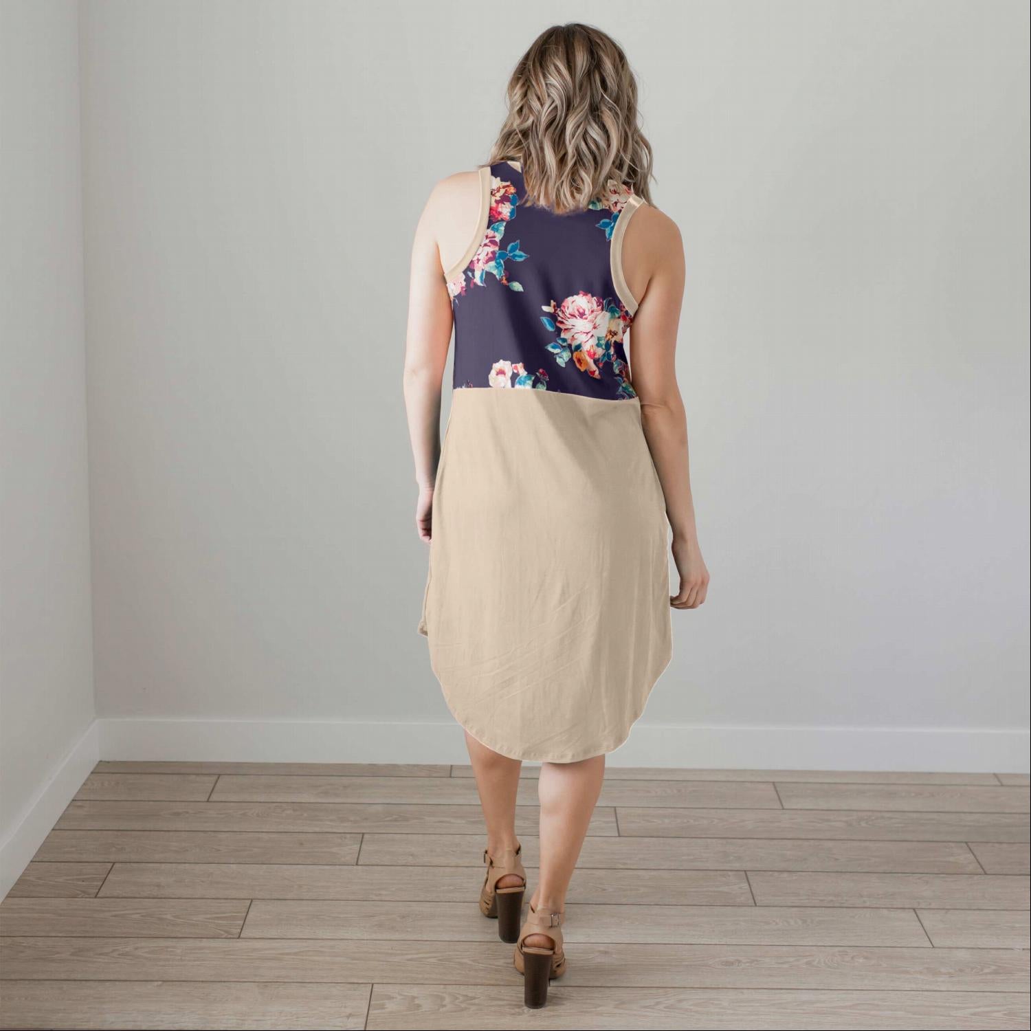 A stylish sleeveless floral dress featuring a pattern-blocked design with a floral top and solid bottom, perfect for summer wear.