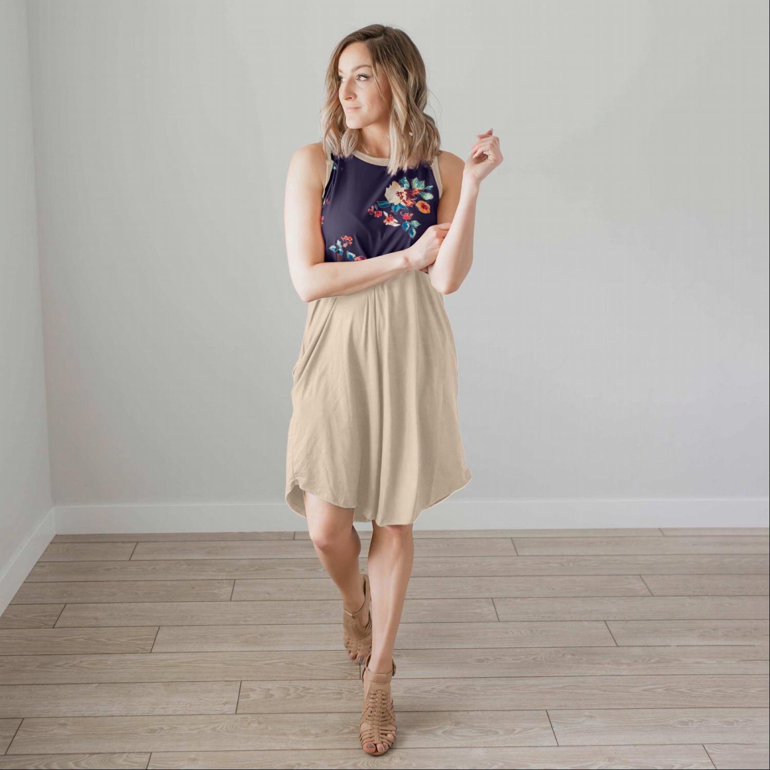 A stylish sleeveless floral dress featuring a pattern-blocked design with a floral top and solid bottom, perfect for summer wear.