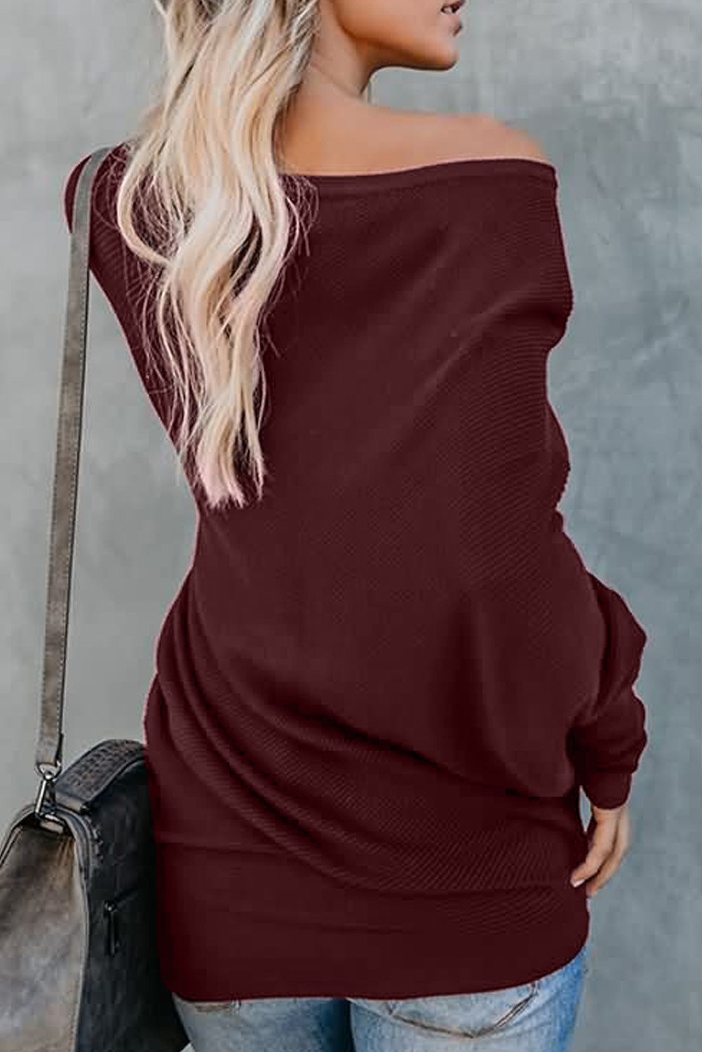 A stylish slouchy one shoulder dolman sleeves ribbed sweater in a solid color, showcasing its relaxed fit and elegant design.