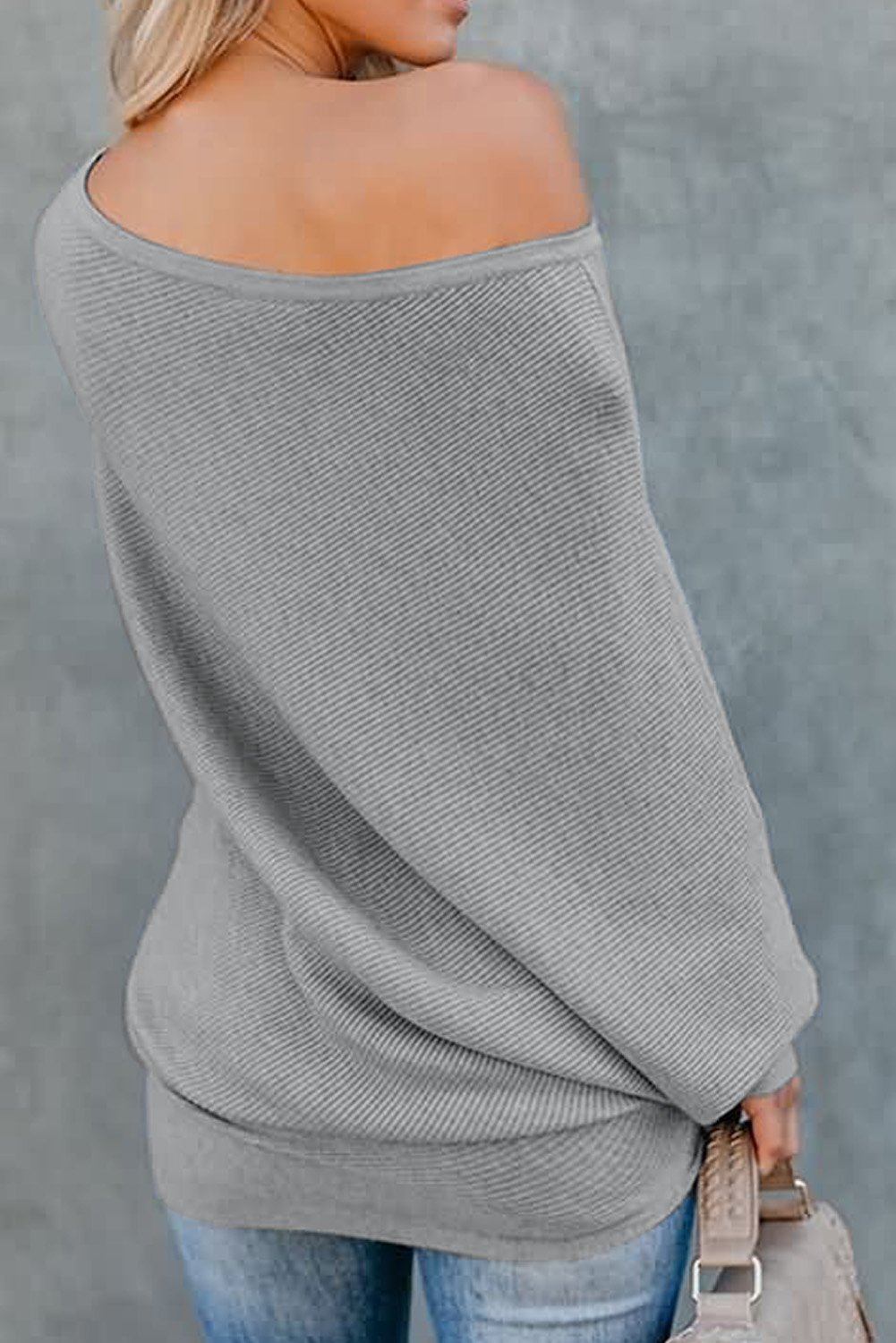 A stylish slouchy one shoulder dolman sleeves ribbed sweater in a solid color, showcasing its relaxed fit and elegant design.