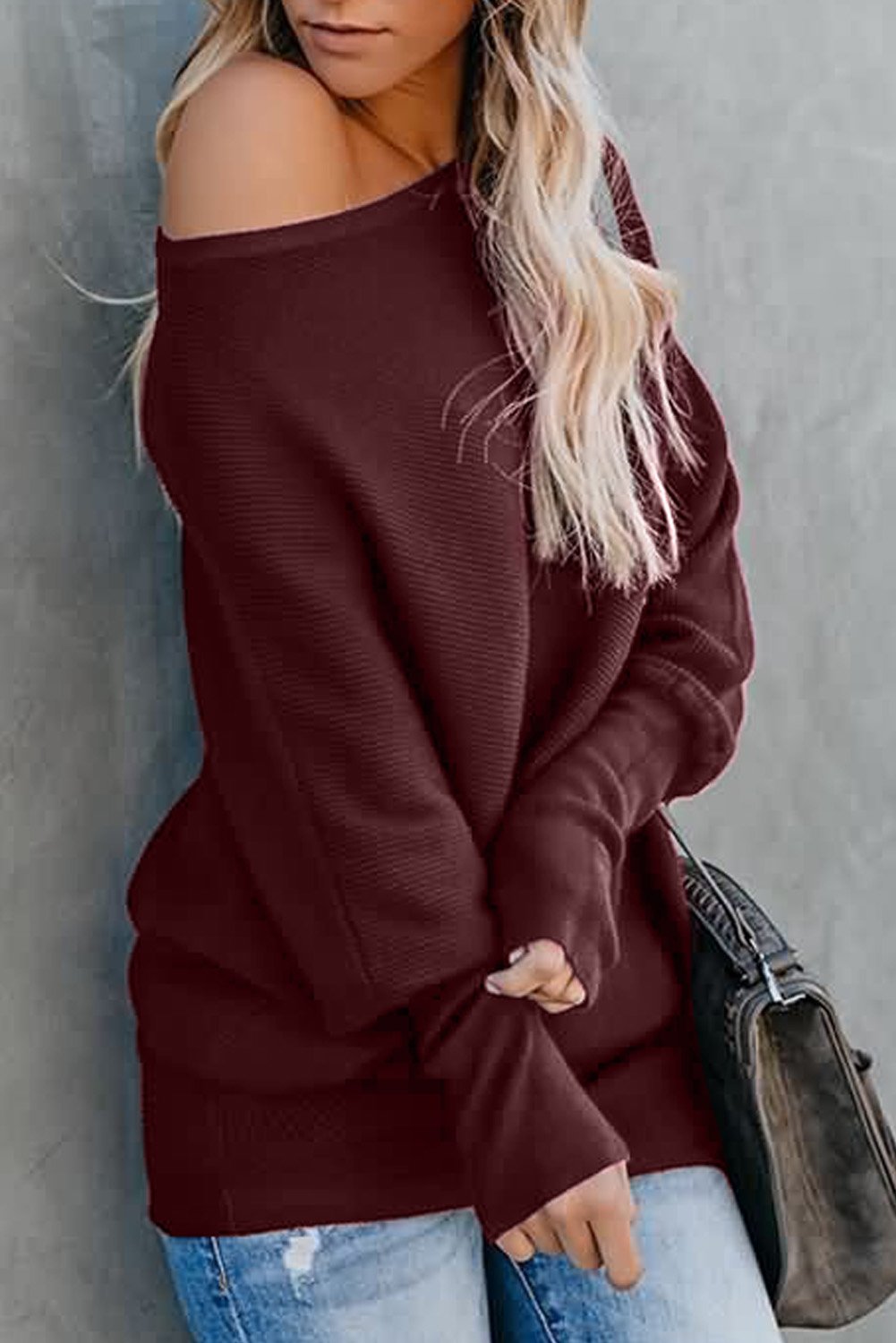 A stylish slouchy one shoulder dolman sleeves ribbed sweater in a solid color, showcasing its relaxed fit and elegant design.