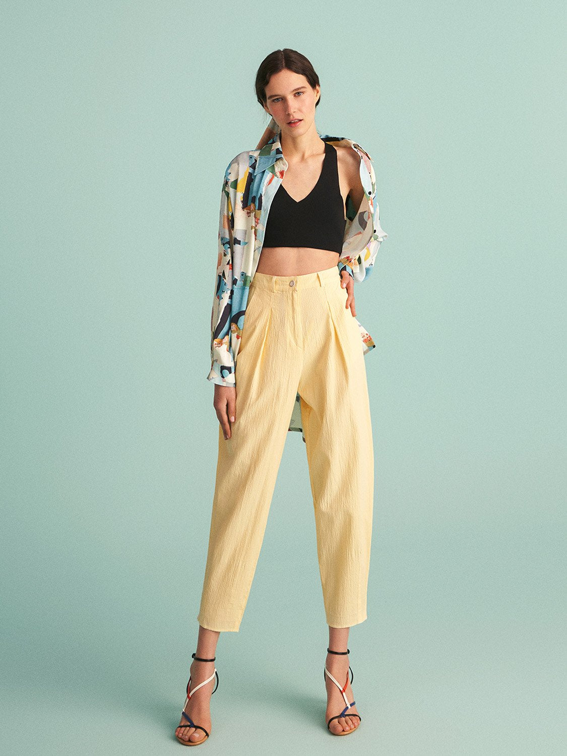 A pair of stylish high-waisted slouchy pants with darts, featuring side pockets and a front zip closure, showcasing a comfortable and chic design.