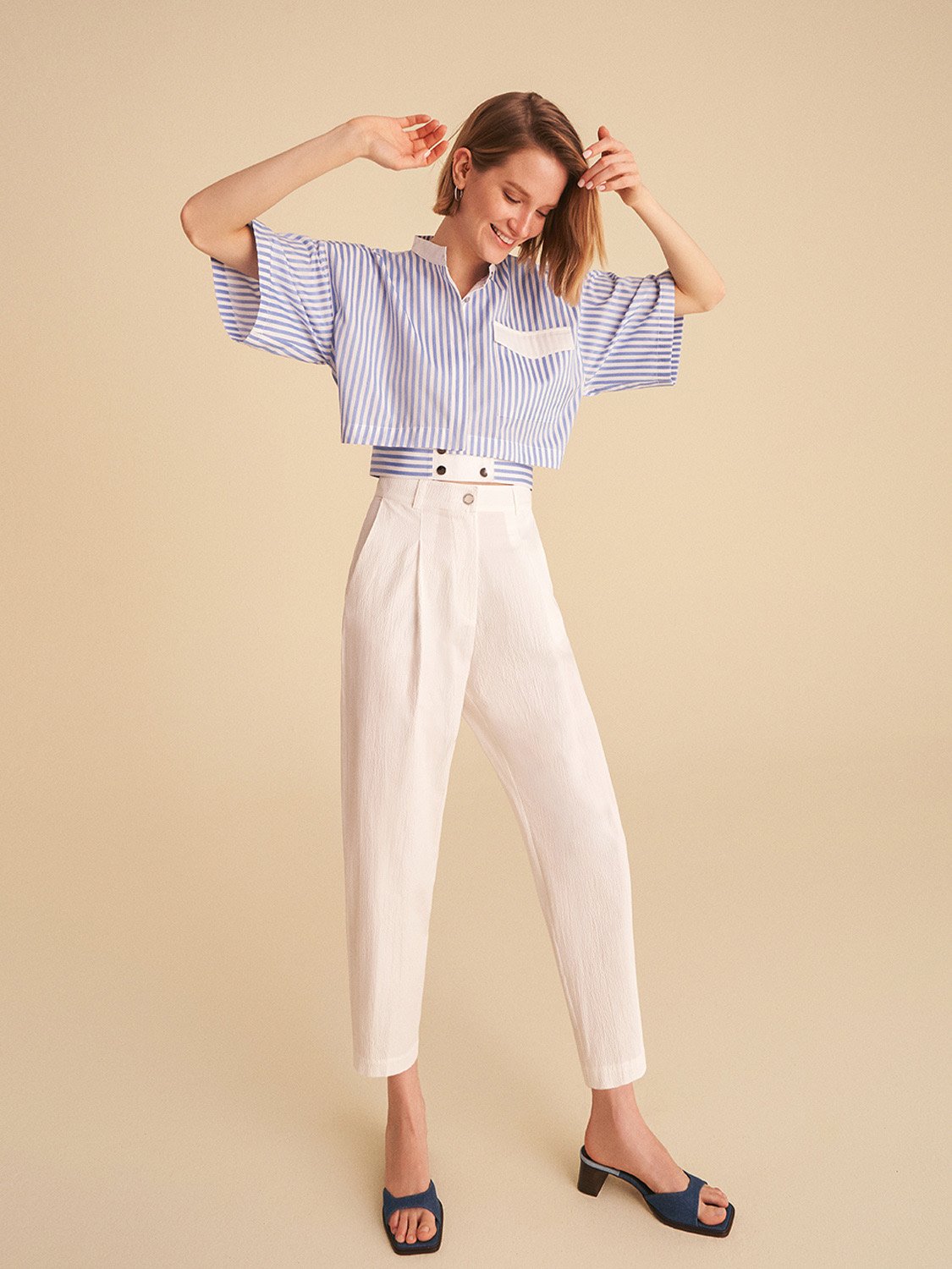 A pair of high-waisted slouchy pants with darts, featuring side pockets and a vibrant blue color, perfect for casual summer wear.