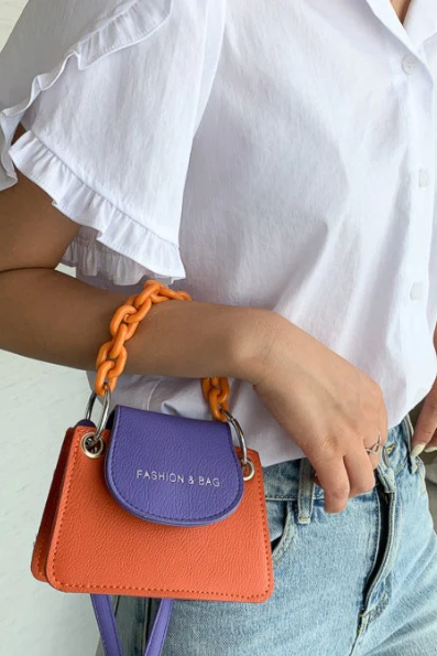 Small orange-violet bag with decorative chain, made of high-quality faux leather, stylish and elegant design.