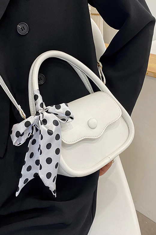 Elegant small white bag with decorative bow, made of high-quality faux leather, featuring a push button closure.