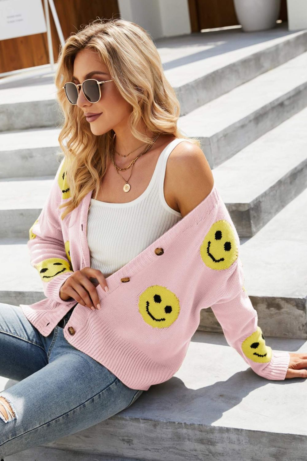 Smiley Face Ribbed Trim V-Neck Cardigan displayed outdoors, featuring a playful smiley face pattern and ribbed trim.