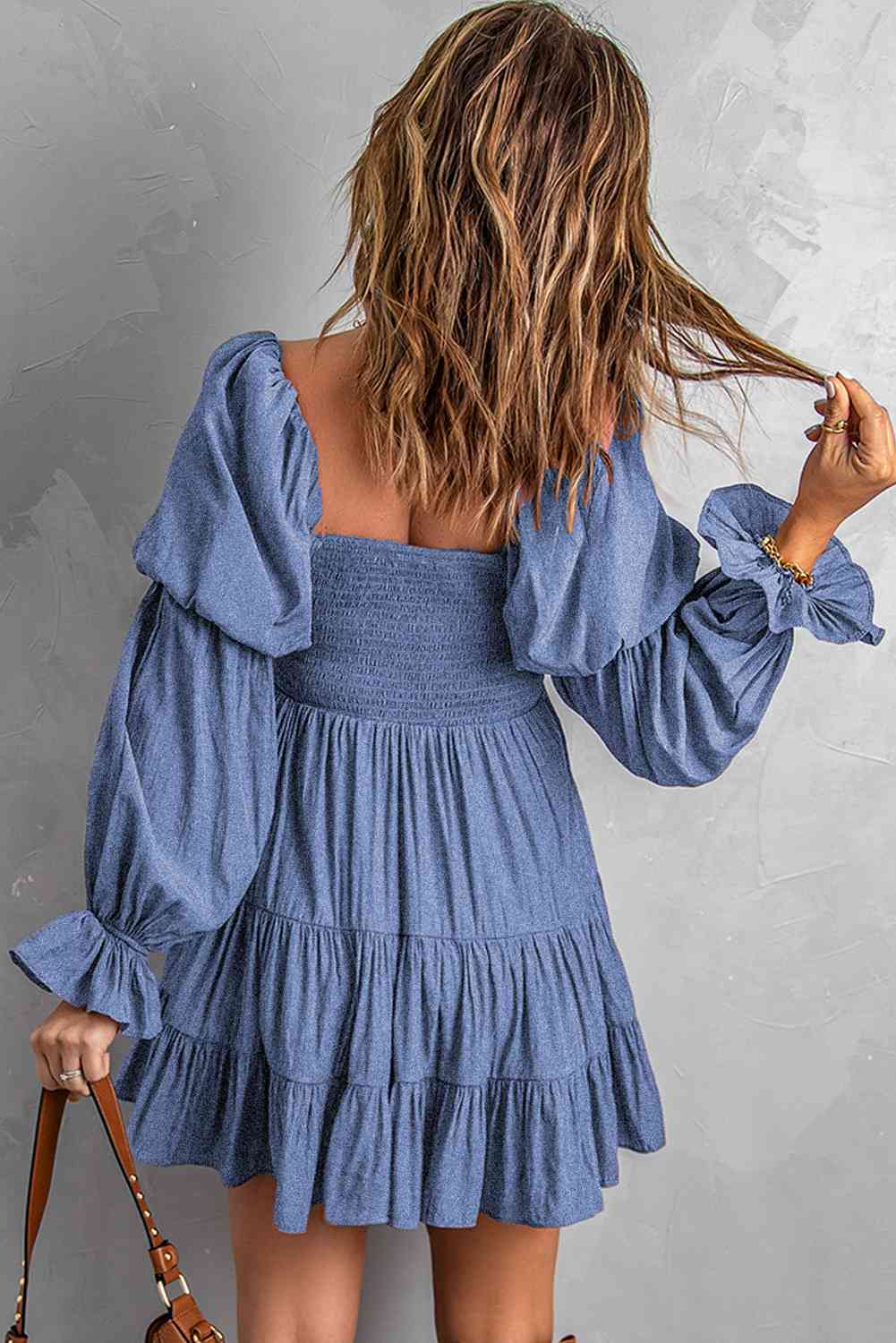 A stylish Smocked Off-Shoulder Tiered Mini Dress featuring flounce sleeves and a chic design, perfect for casual outings.