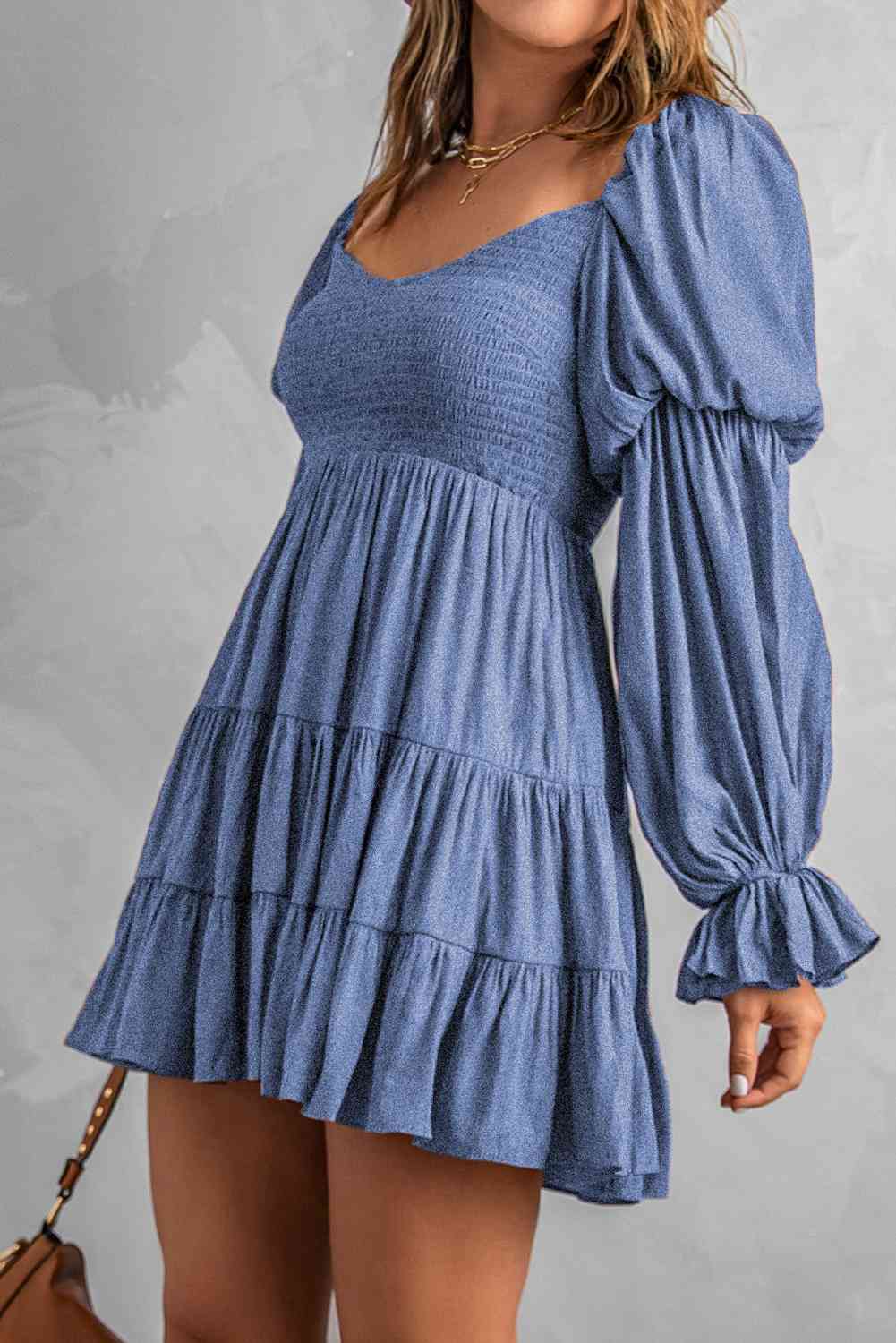 A stylish Smocked Off-Shoulder Tiered Mini Dress featuring flounce sleeves and a chic design, perfect for casual outings.