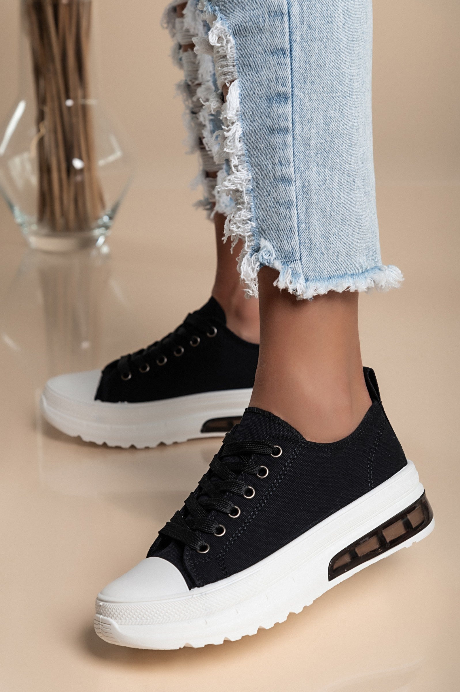 Stylish black sneakers with a raised sole, featuring a round toe and lace-up design, perfect for casual wear.