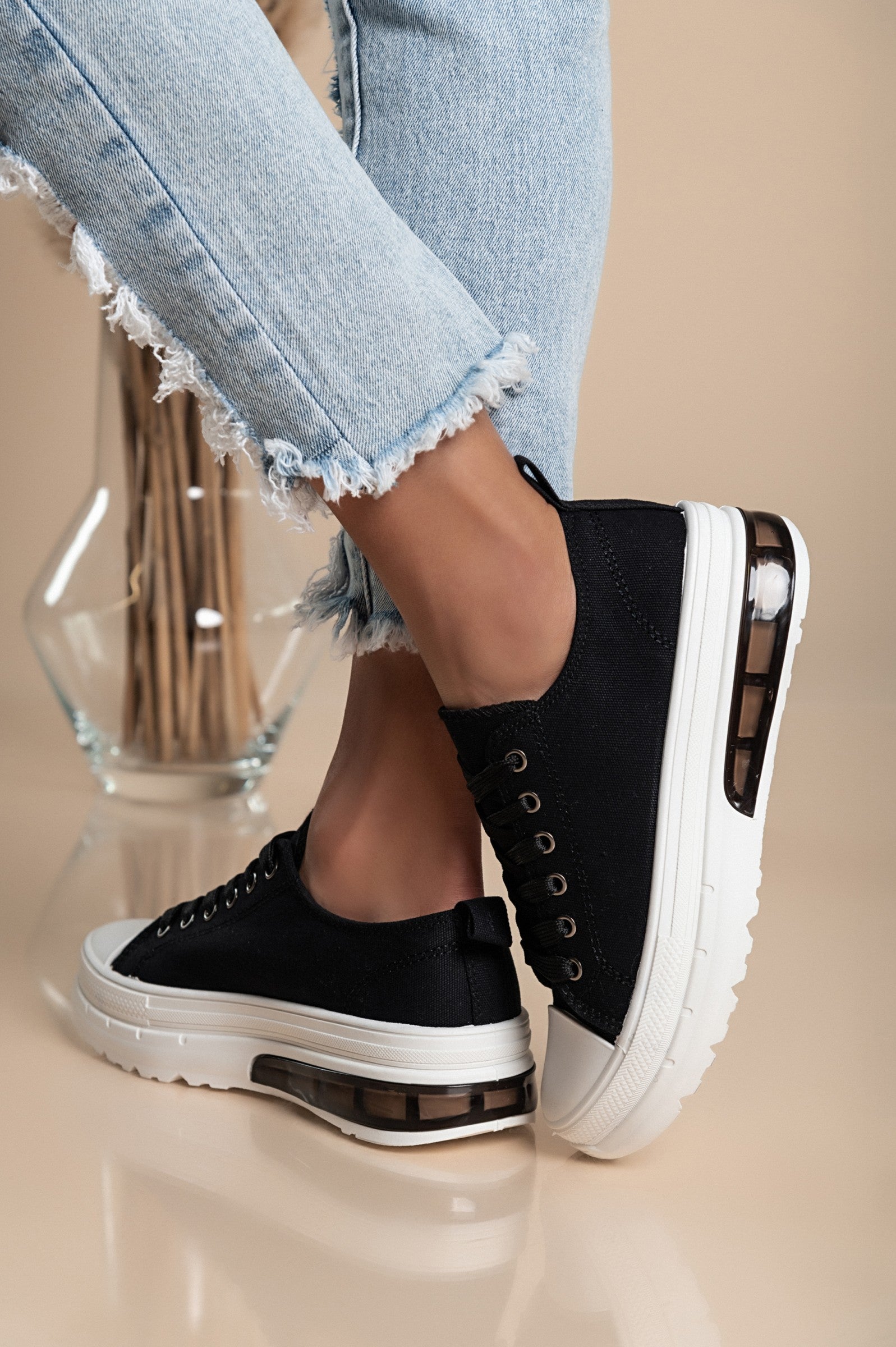 Stylish black sneakers with a raised sole, featuring a round toe and lace-up design, perfect for casual wear.