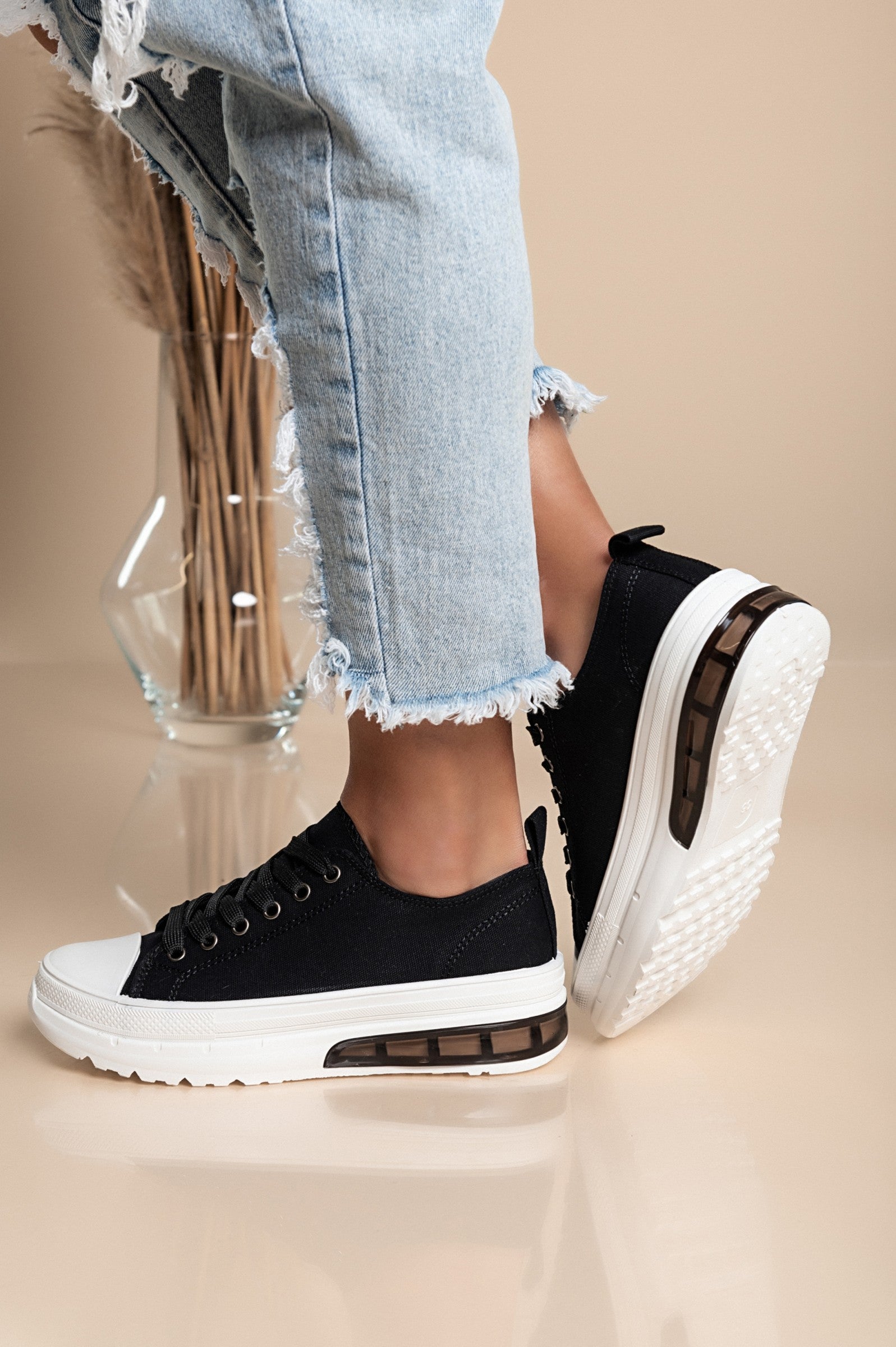 Stylish black sneakers with a raised sole, featuring a round toe and lace-up design, perfect for casual wear.