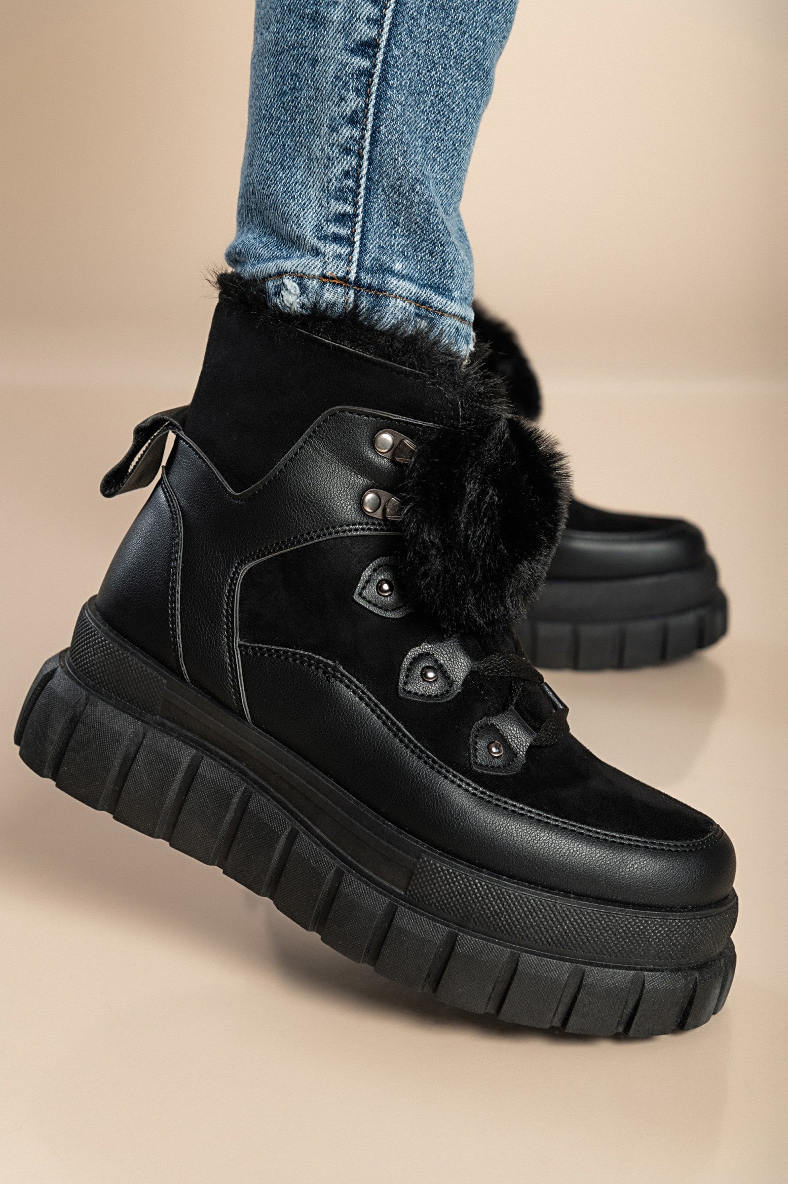 Black fashion sneakers with synthetic fur lining around the ankle and raised sole, featuring a round toe and lace-up closure.