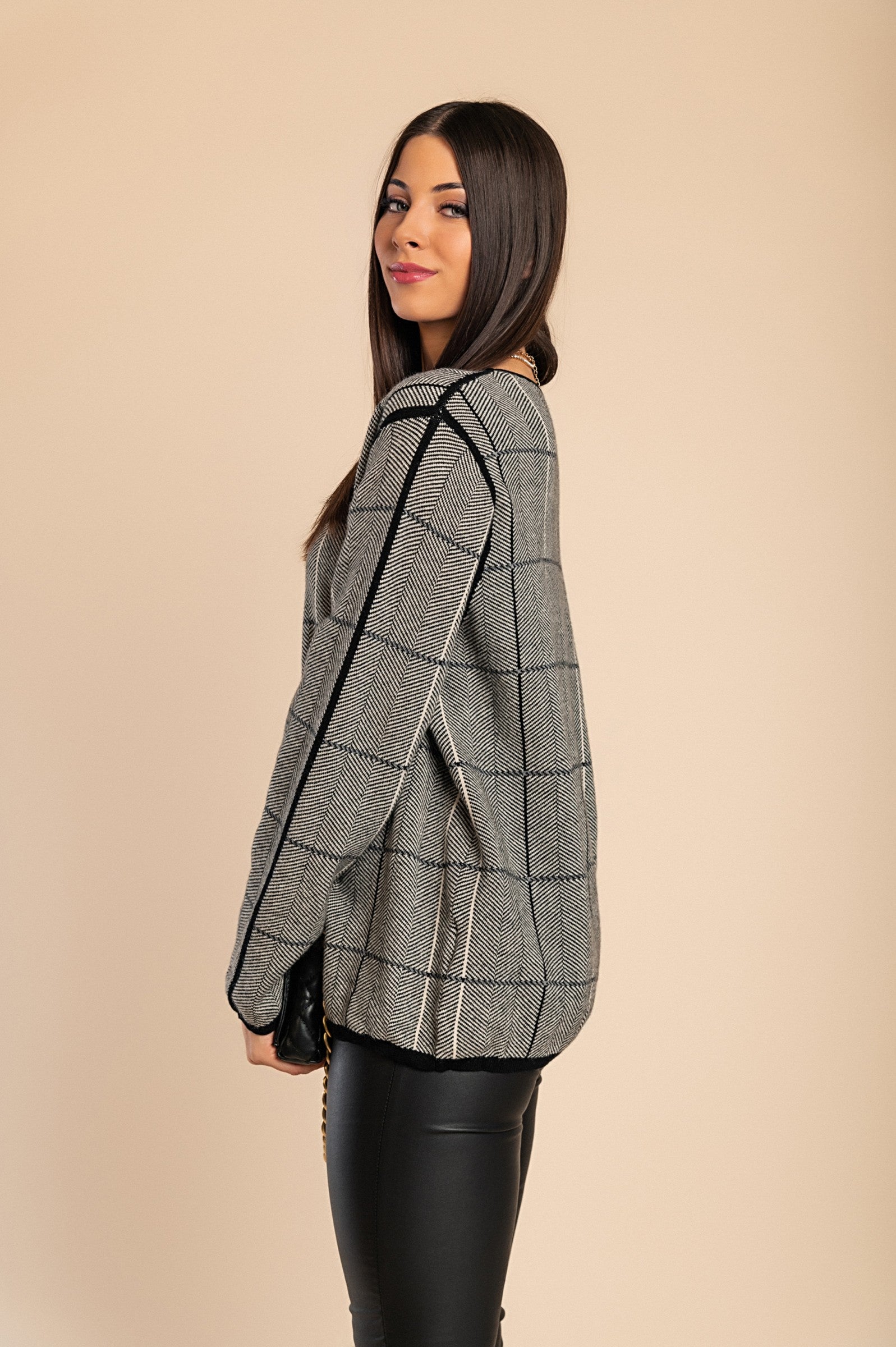 A soft gray sweater featuring a stylish check print, designed with long sleeves and a round neck for ultimate comfort.