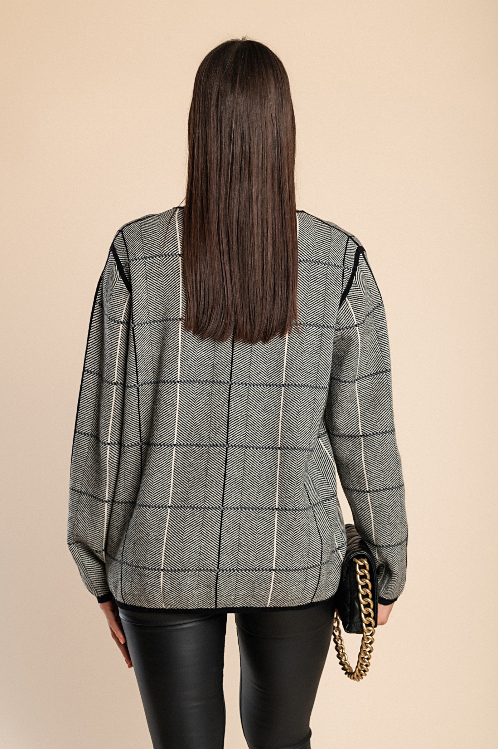 A soft gray sweater featuring a stylish check print, designed with long sleeves and a round neck for ultimate comfort.