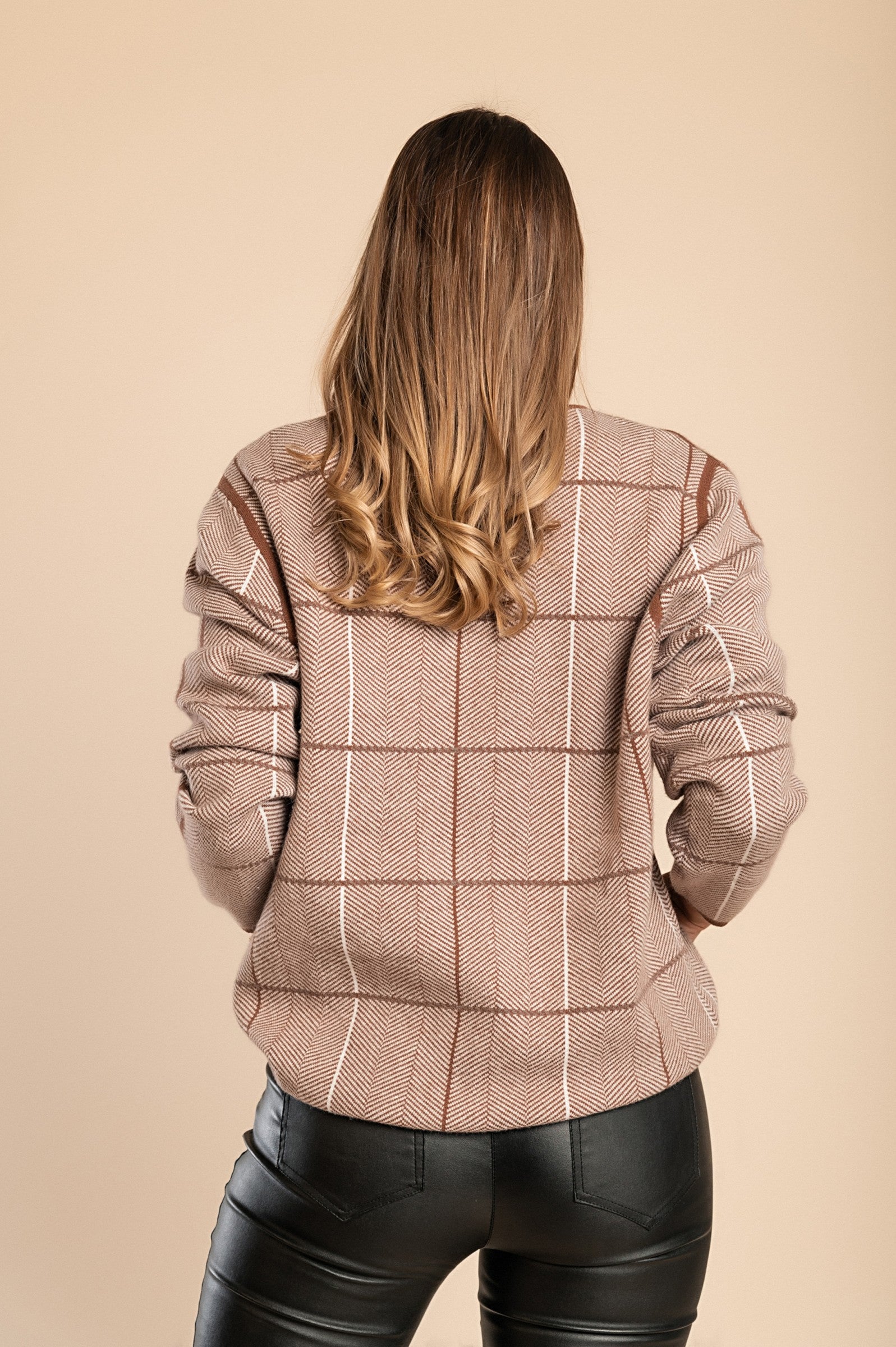 Soft camel sweater with plaid print, featuring long sleeves and a round neck, perfect for cozy outfits.