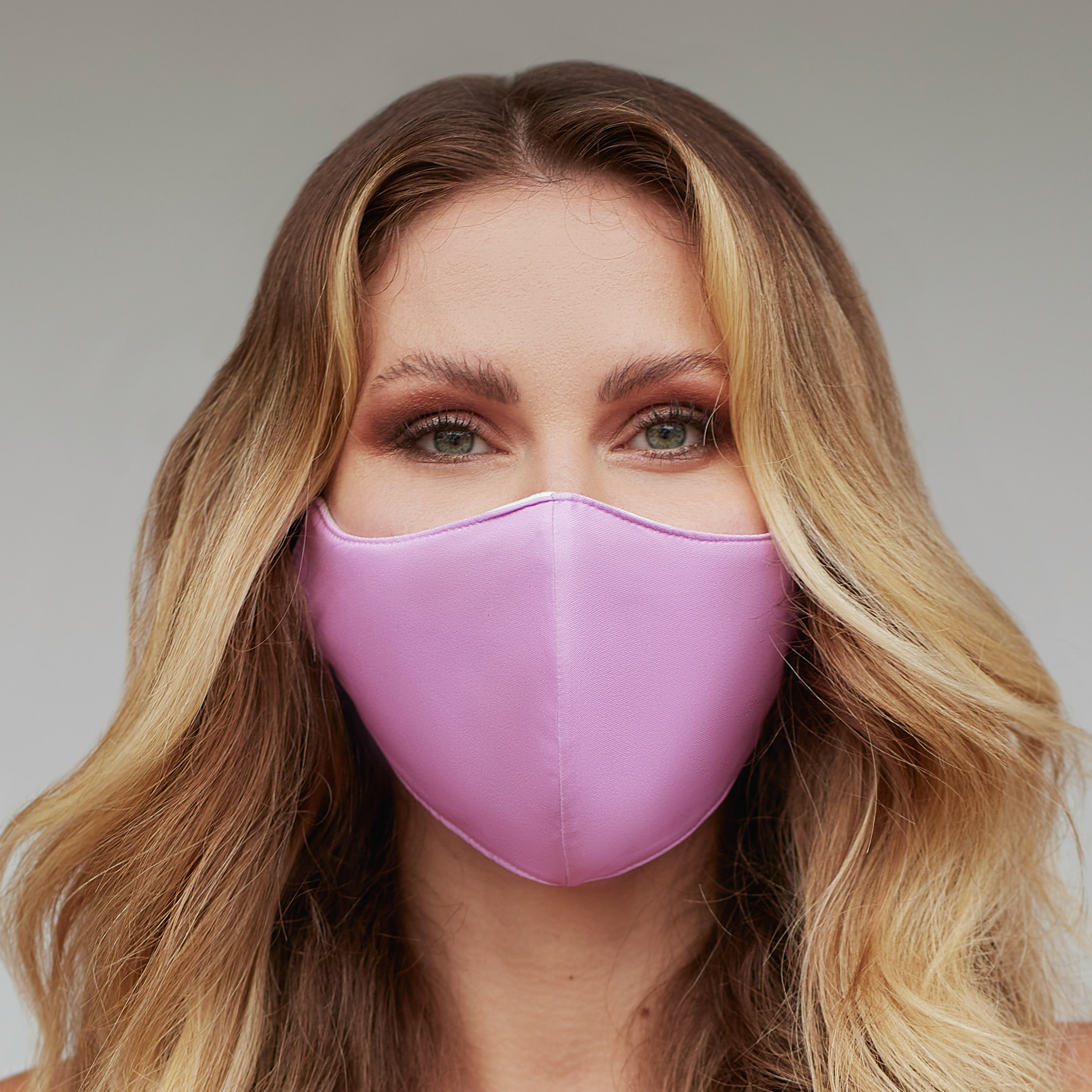 Solid mauve face mask displayed on a neutral background, showcasing its stylish design and adjustable ear loops.