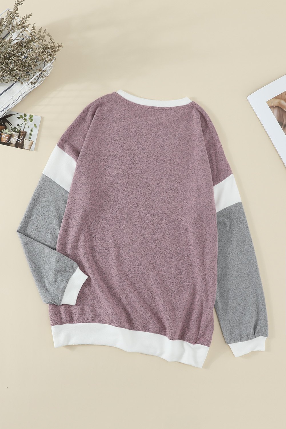 A stylish brown knit top featuring splicing sleeves, contrast neckline, and cuffs, perfect for casual wear.