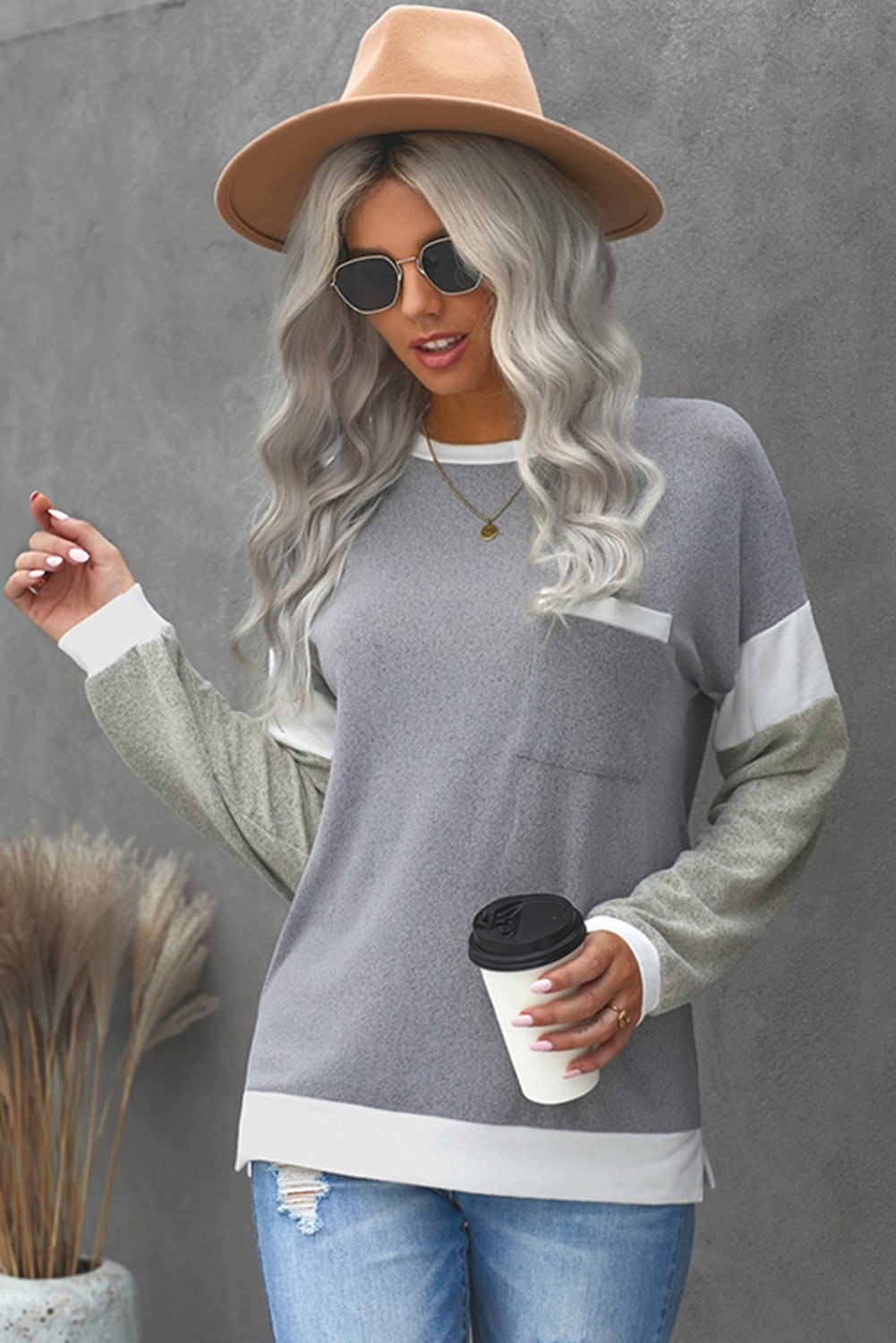 A stylish brown knit top featuring splicing sleeves, contrast neckline, and cuffs, perfect for casual wear.