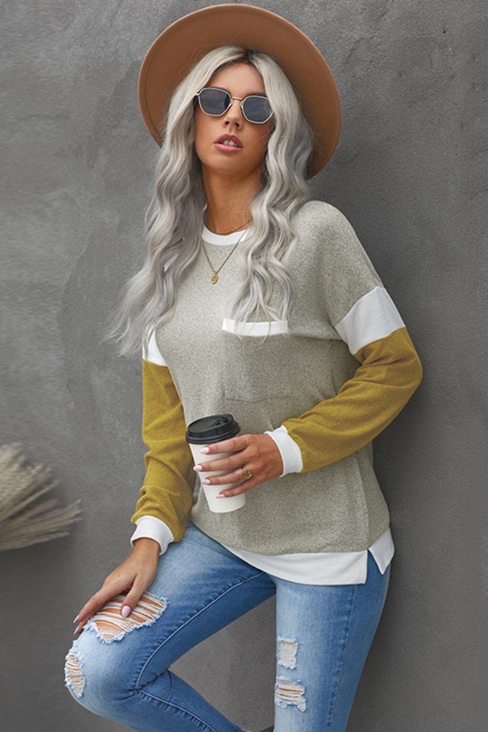 A stylish brown knit top featuring splicing sleeves, contrast neckline, and cuffs, perfect for casual wear.