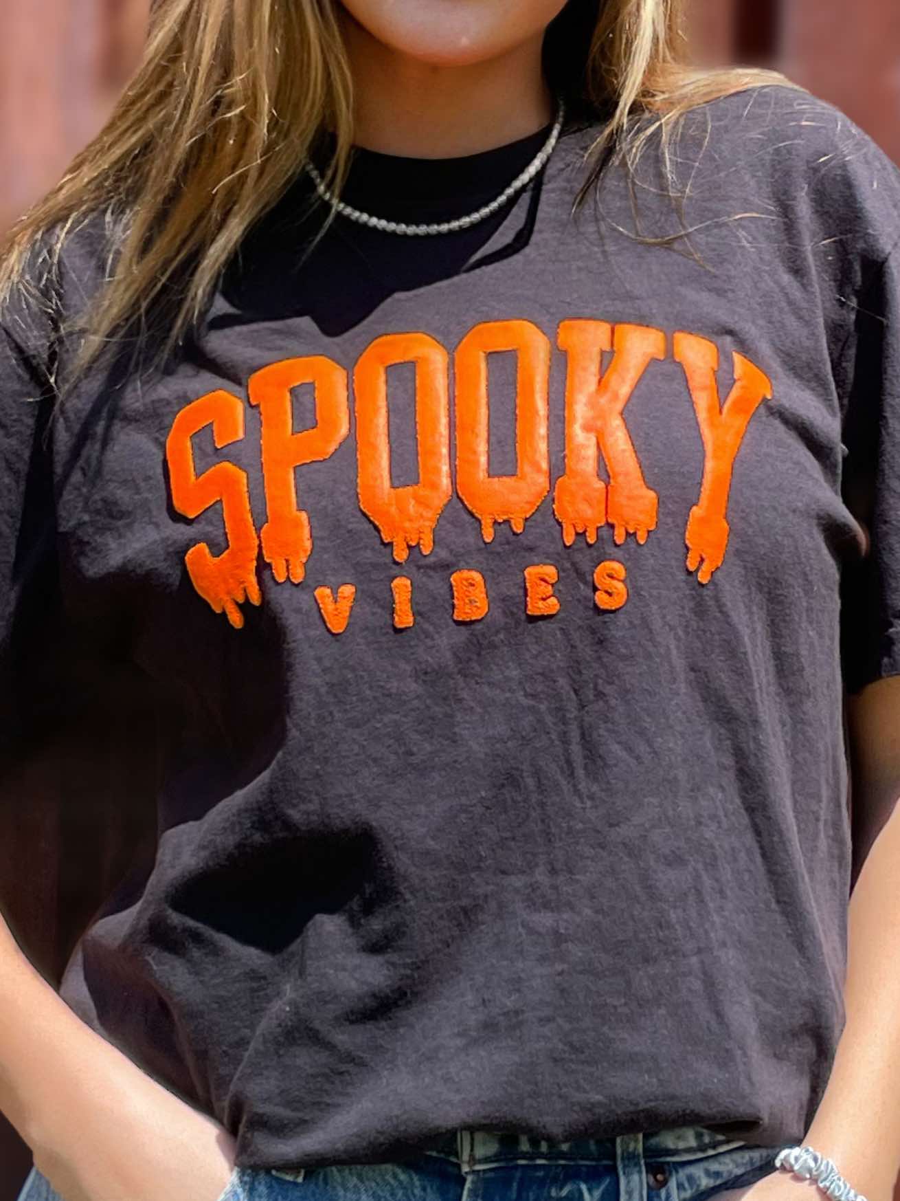 A black unisex tee featuring spooky graphics, perfect for Halloween celebrations.