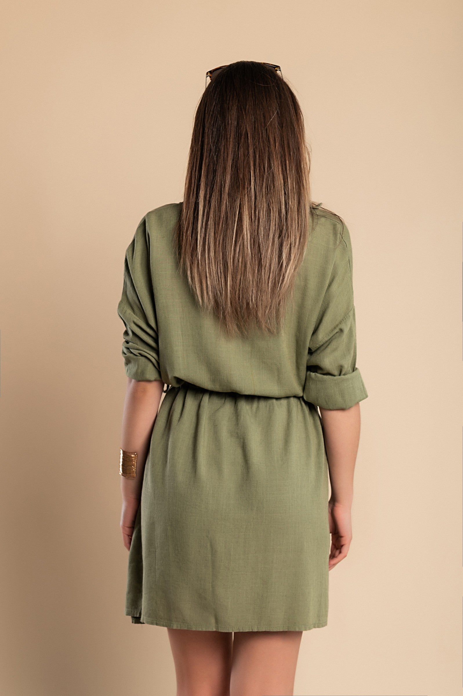 Olive green SPORT MINI DRESS featuring a classic collar, long sleeves, decorative front pocket, and side slits for a stylish look.