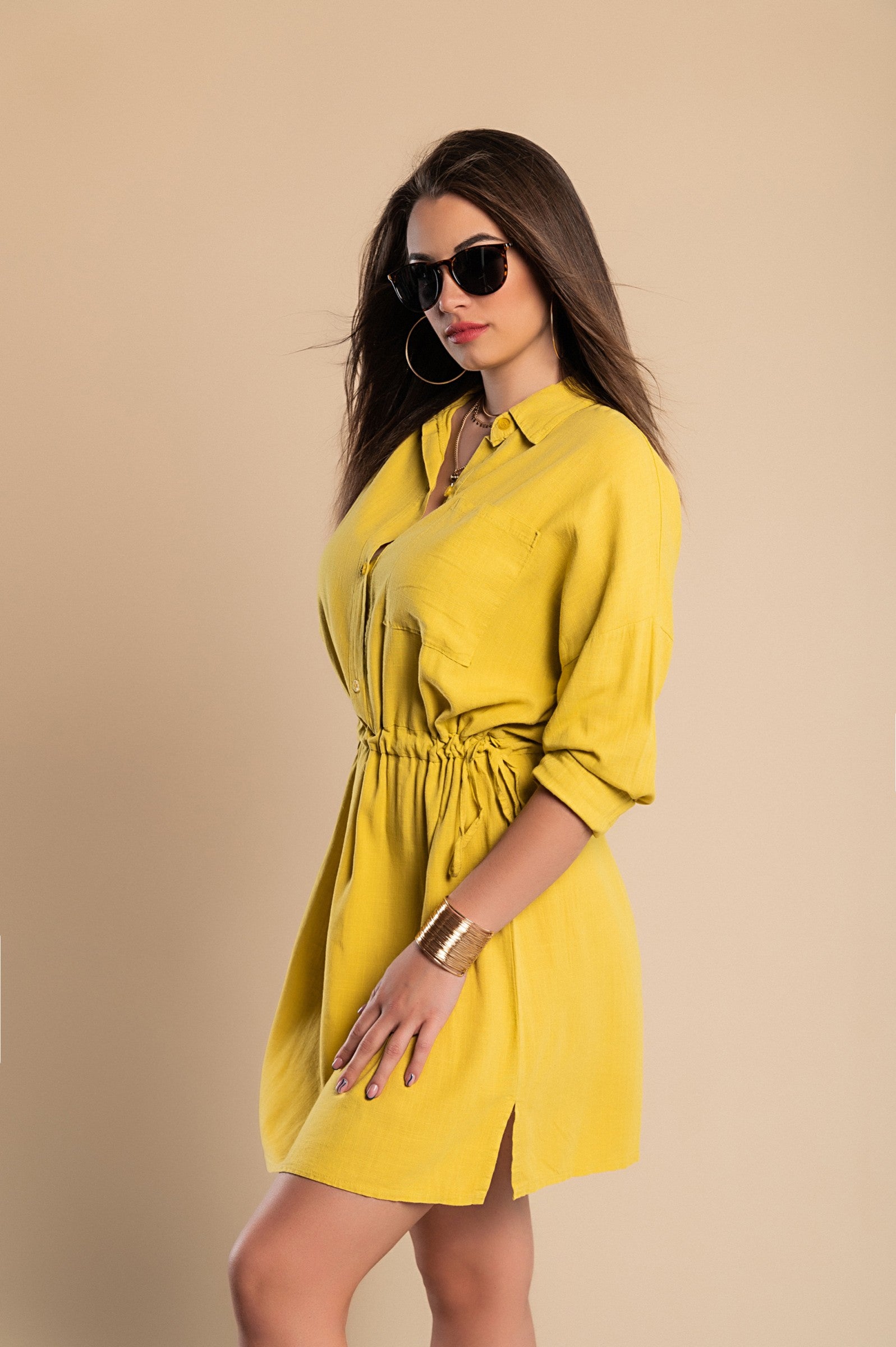 A vibrant yellow SPORT MINI DRESS featuring a classic collar, long sleeves, decorative front pocket, and mid-thigh skirt with side slits.