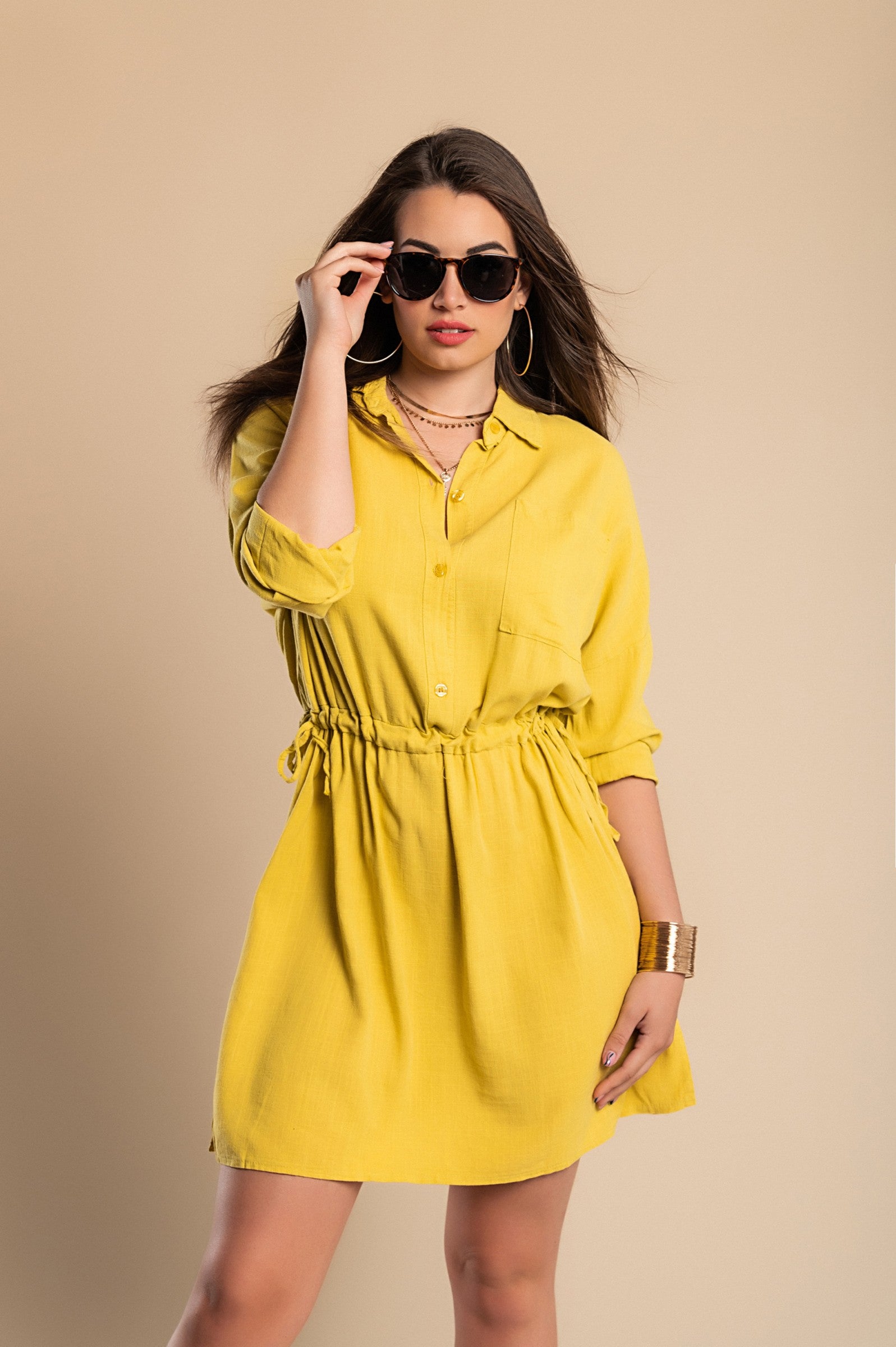 A vibrant yellow SPORT MINI DRESS featuring a classic collar, long sleeves, decorative front pocket, and mid-thigh skirt with side slits.