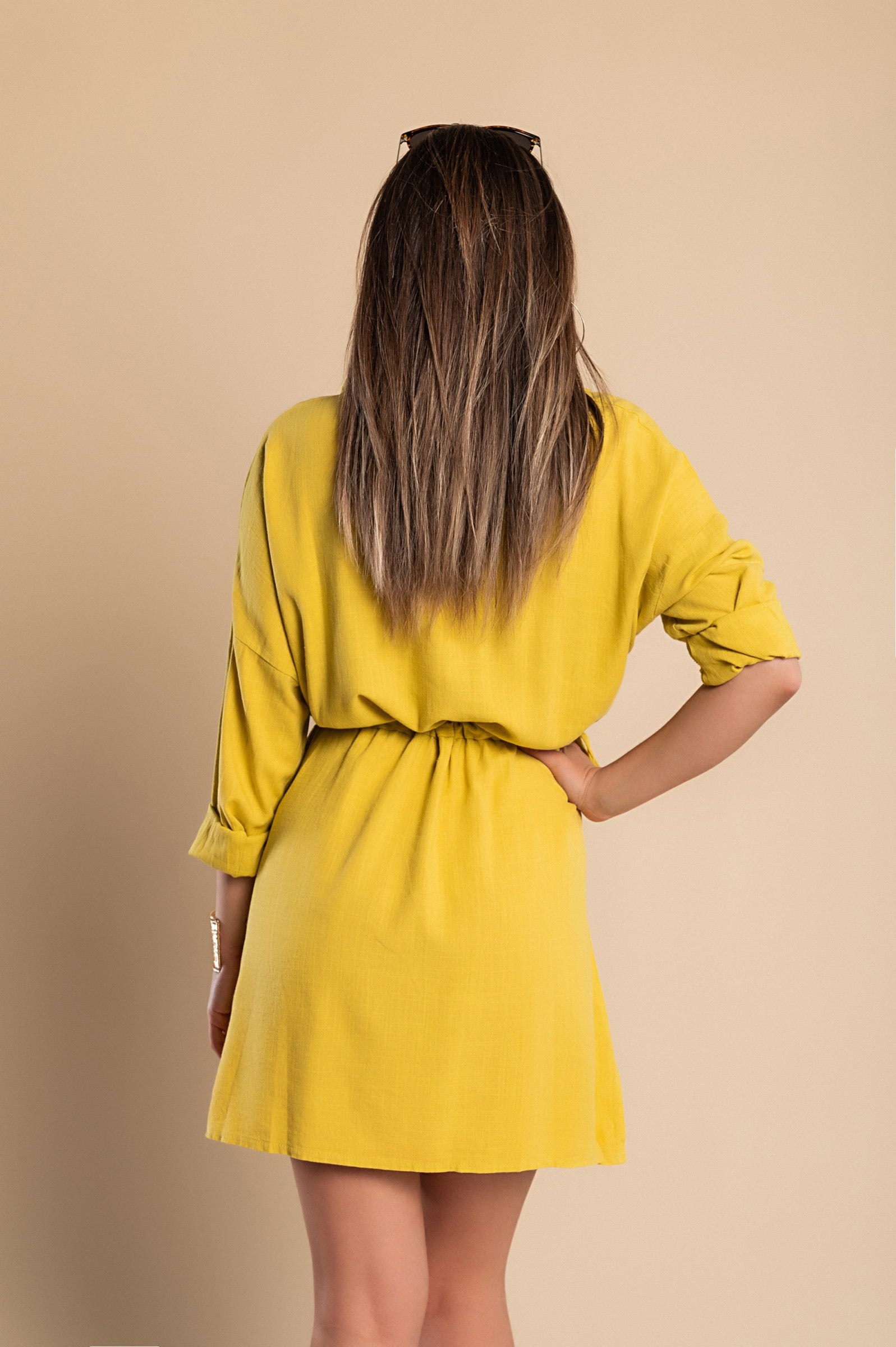 A vibrant yellow SPORT MINI DRESS featuring a classic collar, long sleeves, decorative front pocket, and mid-thigh skirt with side slits.