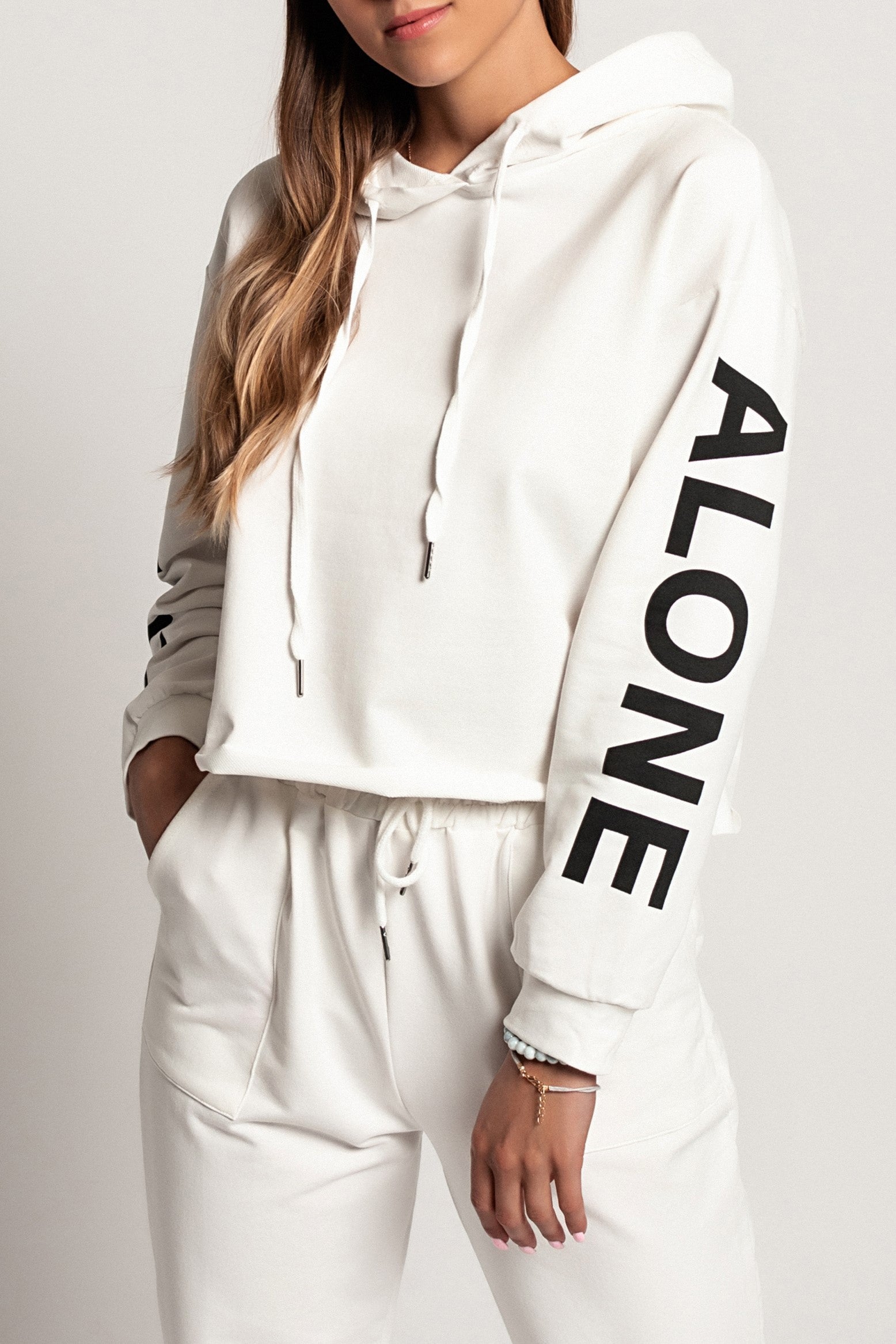 Sporty white hoodie with printed long sleeves and drawstring hood, showcasing a comfortable and stylish design.