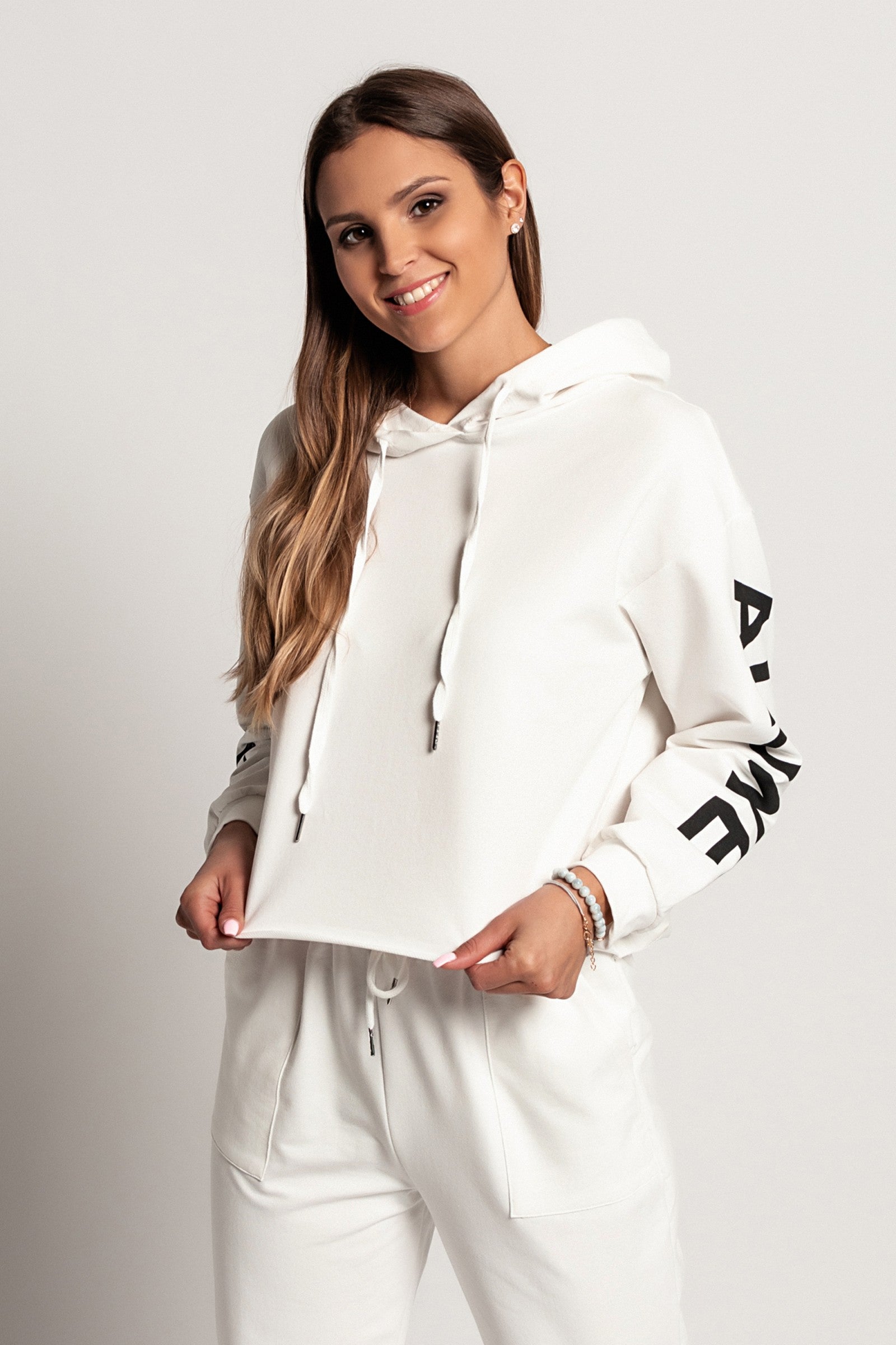 Sporty white hoodie with printed long sleeves and drawstring hood, showcasing a comfortable and stylish design.