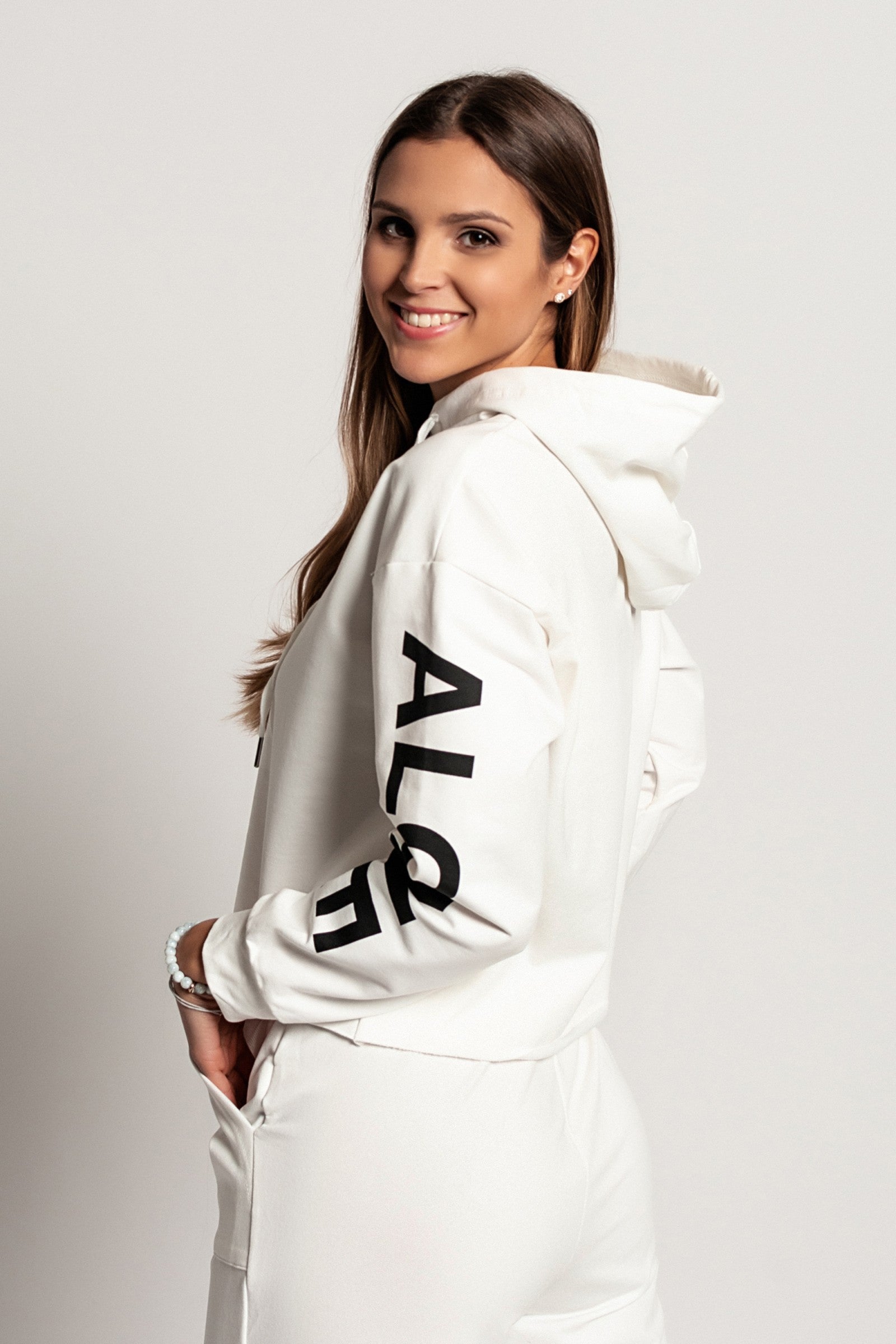 Sporty white hoodie with printed long sleeves and drawstring hood, showcasing a comfortable and stylish design.