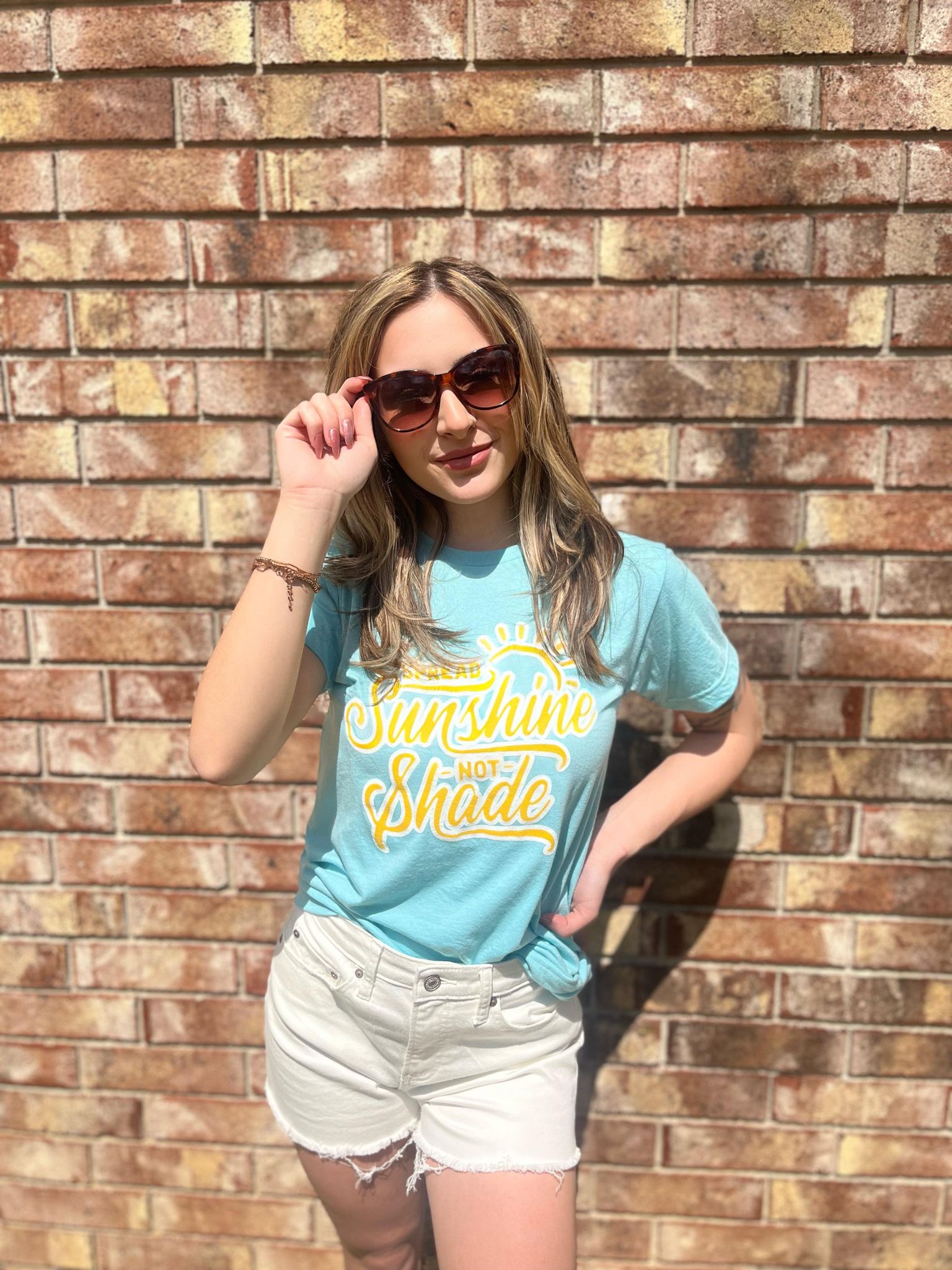 A vibrant unisex t-shirt with the phrase 'Spread Sunshine Not Shade' printed in colorful letters, showcasing a soft fabric and true-to-size fit.