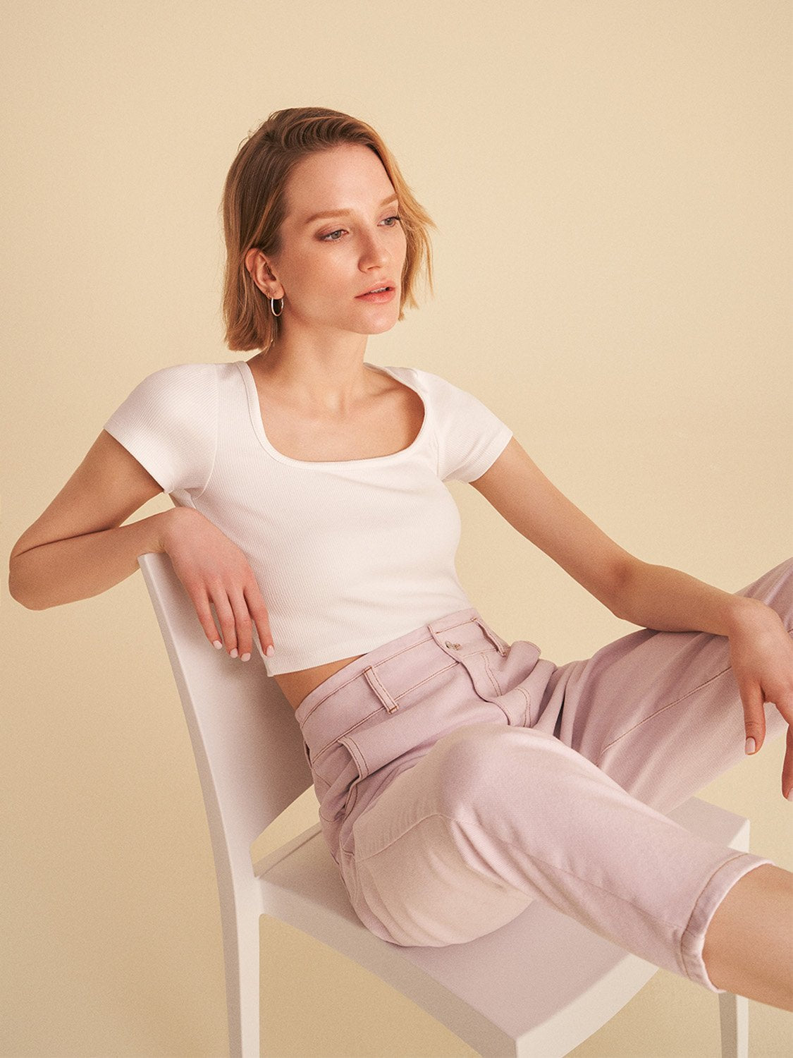 A stylish square neck crop top with short sleeves featuring vibrant digital collage patterns in hues of pink and white.