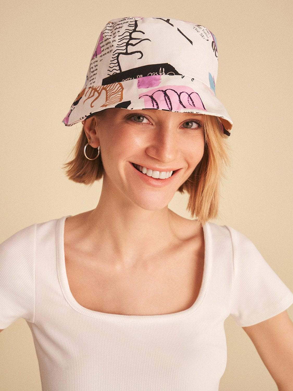 A stylish square neck crop top with short sleeves featuring vibrant digital collage patterns in hues of pink and white.