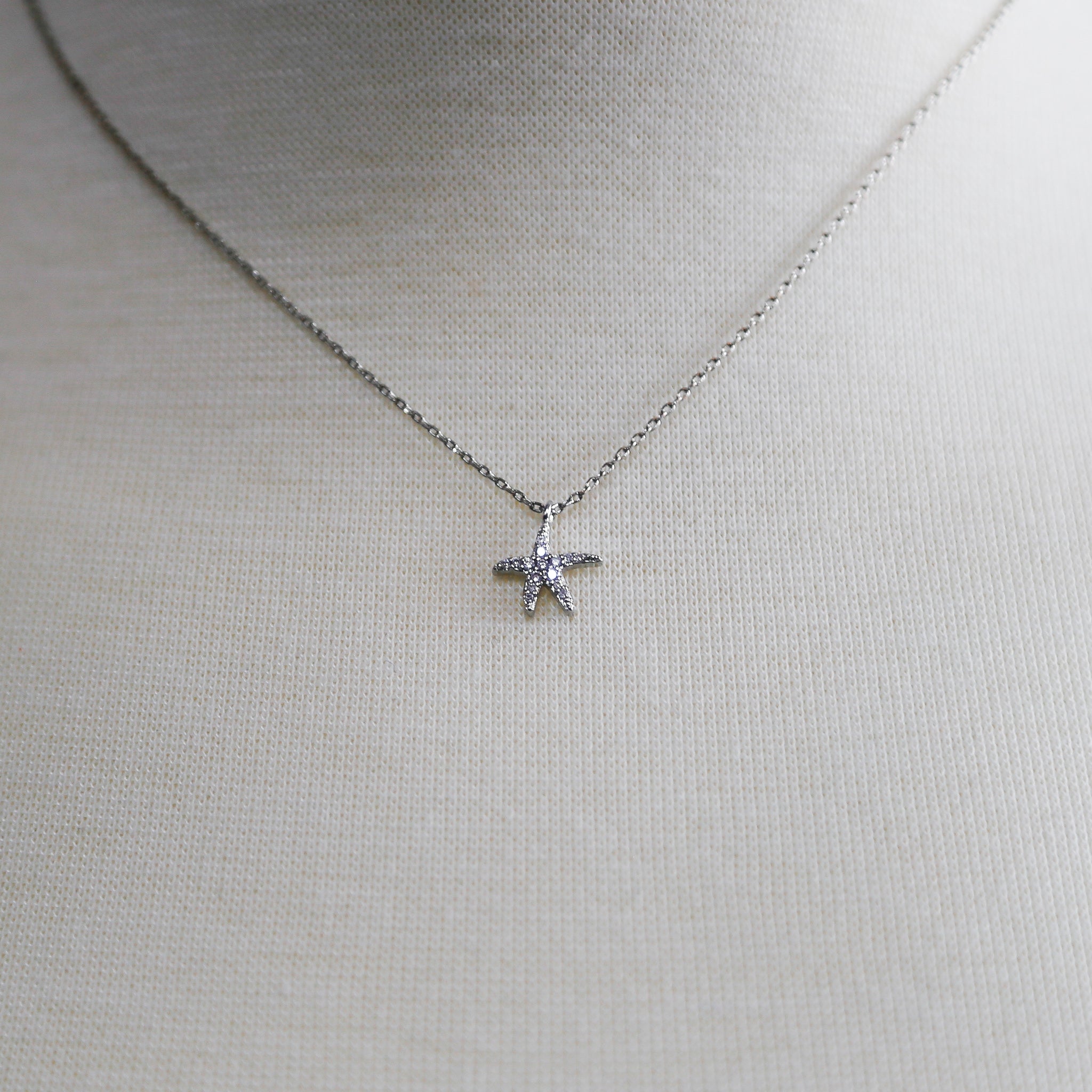 A high-polish Starry Seas Necklace featuring a star pendant on a cable chain, showcasing elegance and charm.