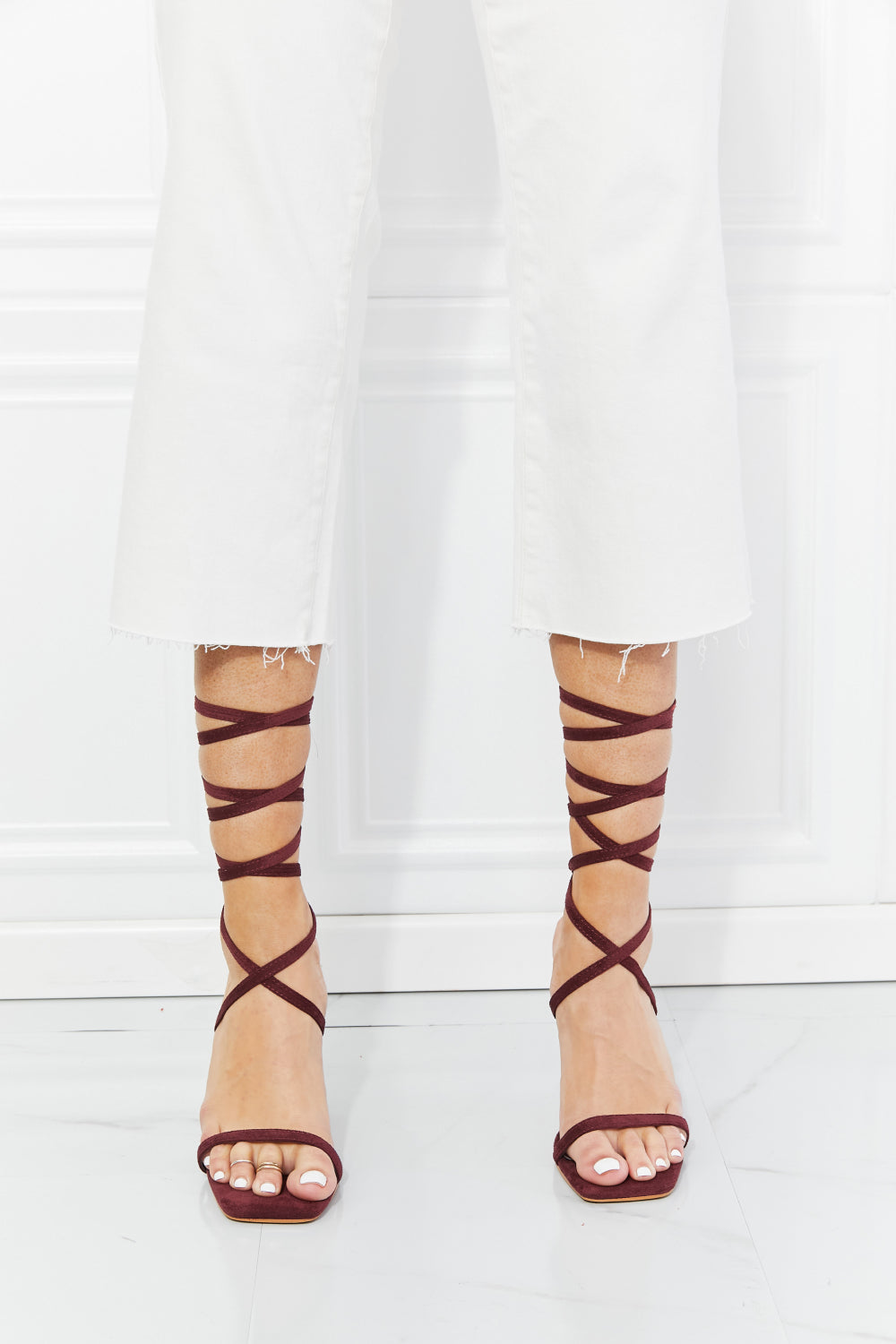 Stylish strappy open-toe heels with a high stiletto heel, showcasing a lace-up design and solid fabric upper.