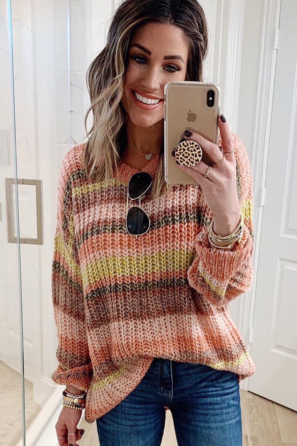 A vibrant Stripe Color Block Chunky Sweater featuring a mix of cream, pink, orange, yellow, and red stripes, showcasing a relaxed fit and long sleeves.