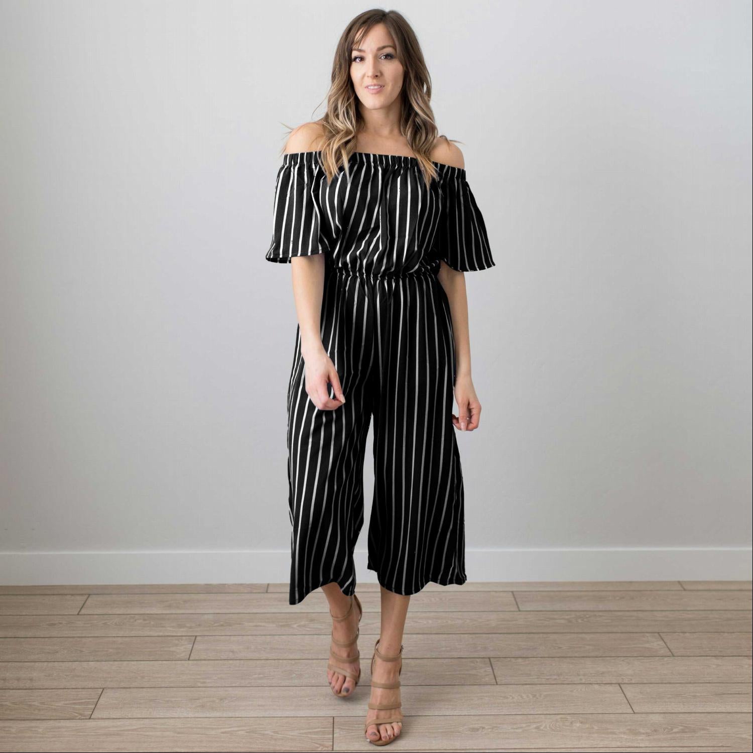 A stylish striped elbow sleeved woven jumpsuit featuring an off-the-shoulder neckline and a gaucho fit, perfect for spring and summer.