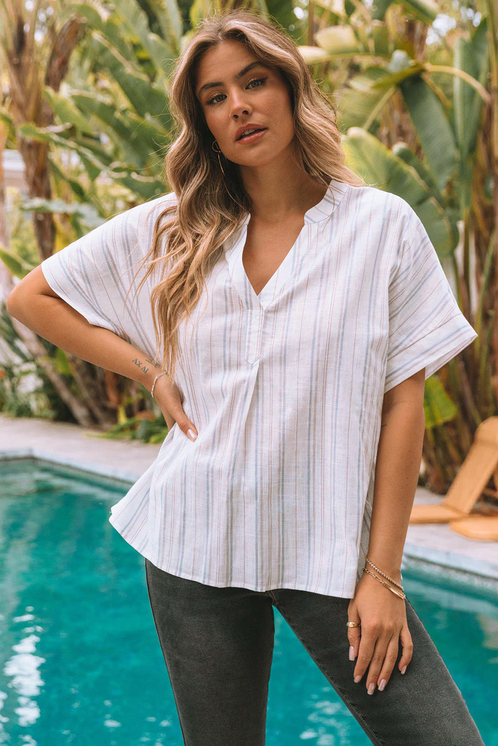 A stylish striped print loose fit top featuring a v-neckline and side slits, perfect for casual wear and layering.