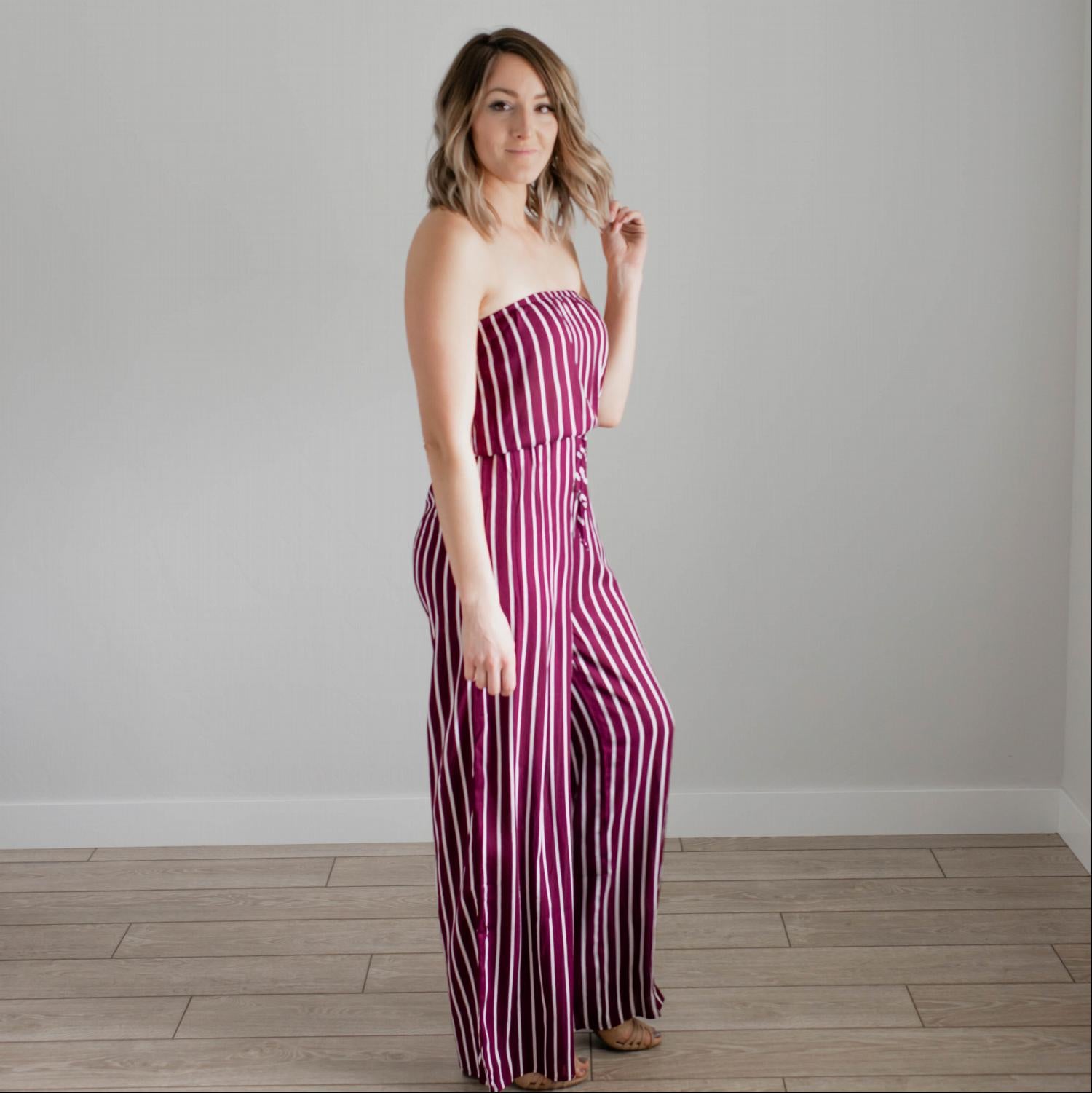 A stylish striped tube jumpsuit featuring a tube top neckline, vertical stripes, and a modest flare leg, perfect for various occasions.