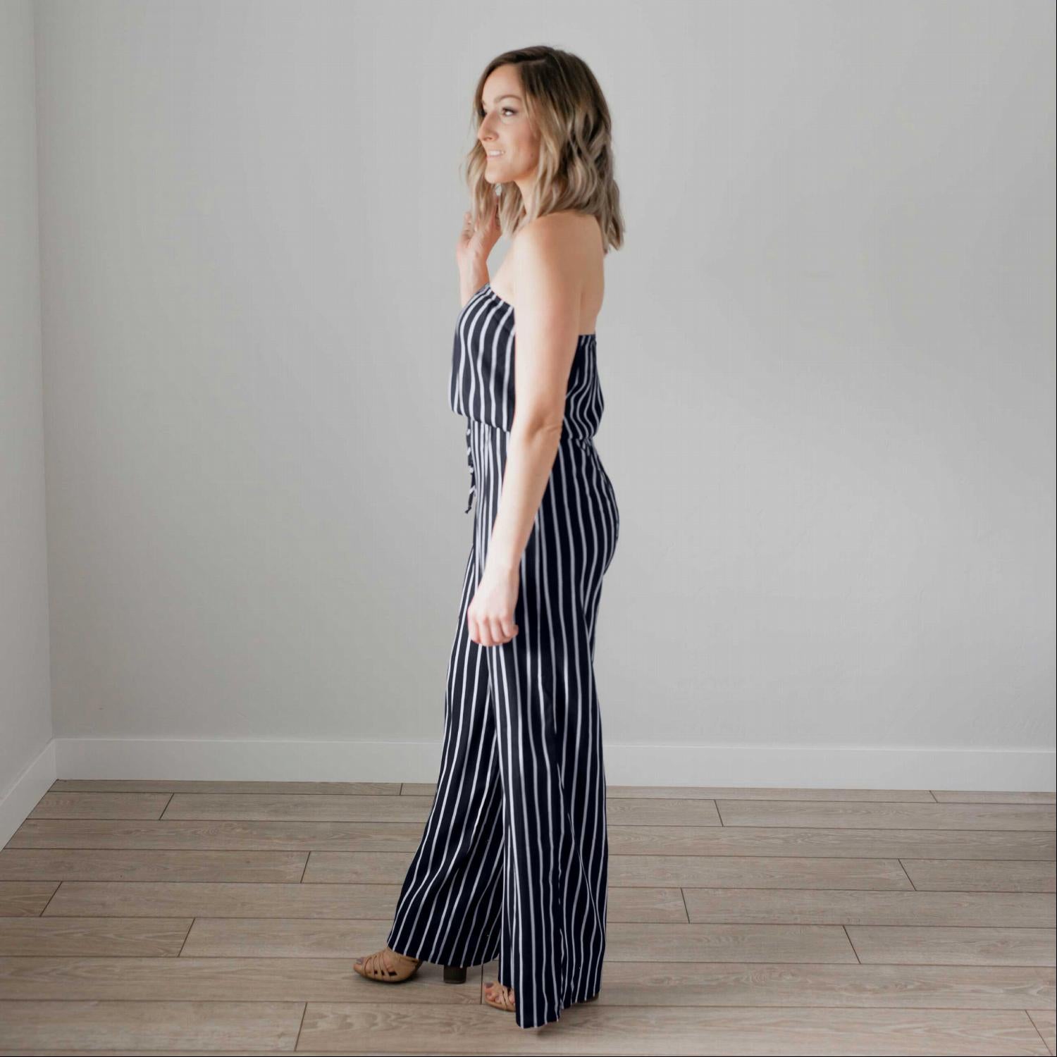 A stylish striped tube jumpsuit featuring a tube top neckline, vertical stripes, and a modest flare leg, perfect for various occasions.