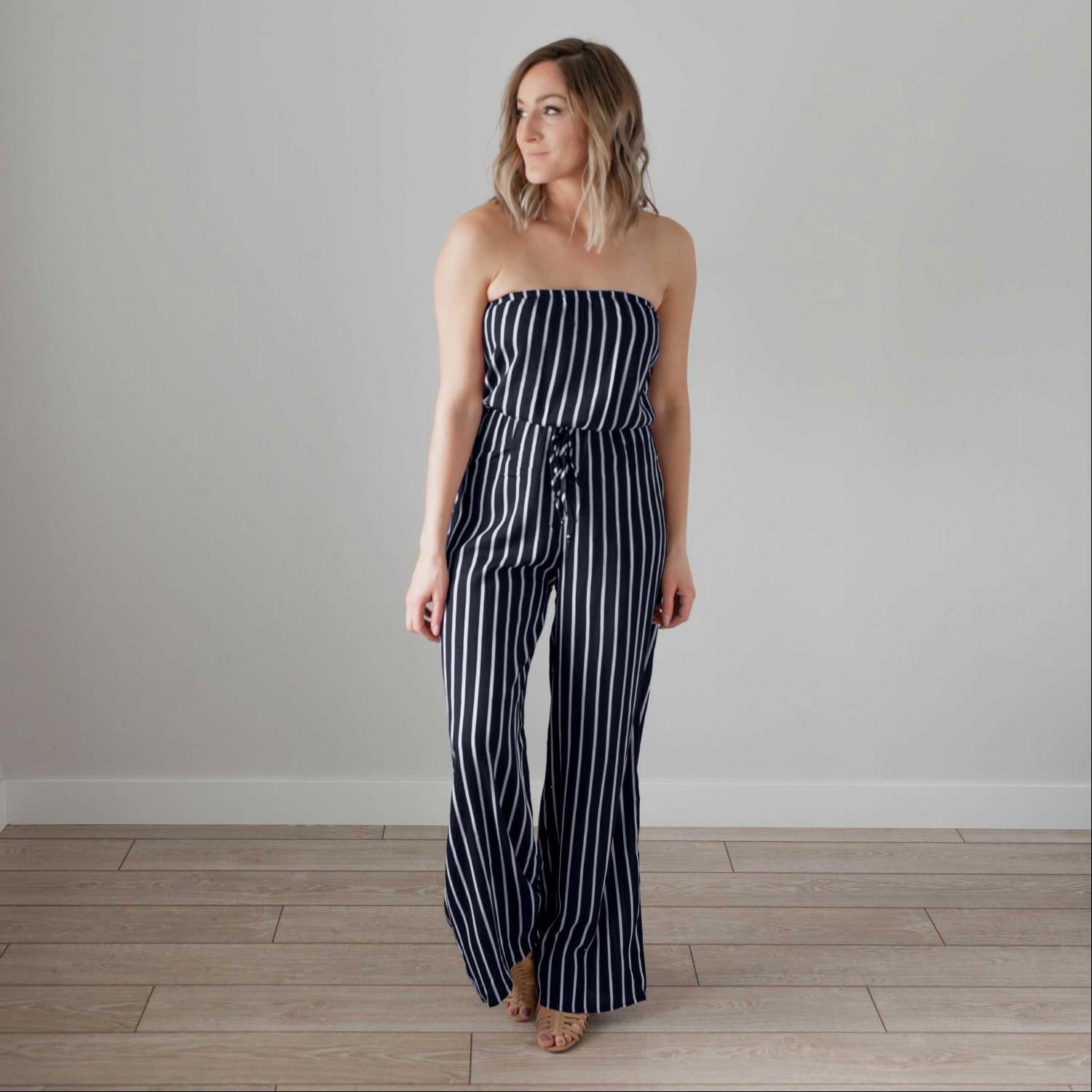 A stylish striped tube jumpsuit featuring a tube top neckline, vertical stripes, and a modest flare leg, perfect for various occasions.